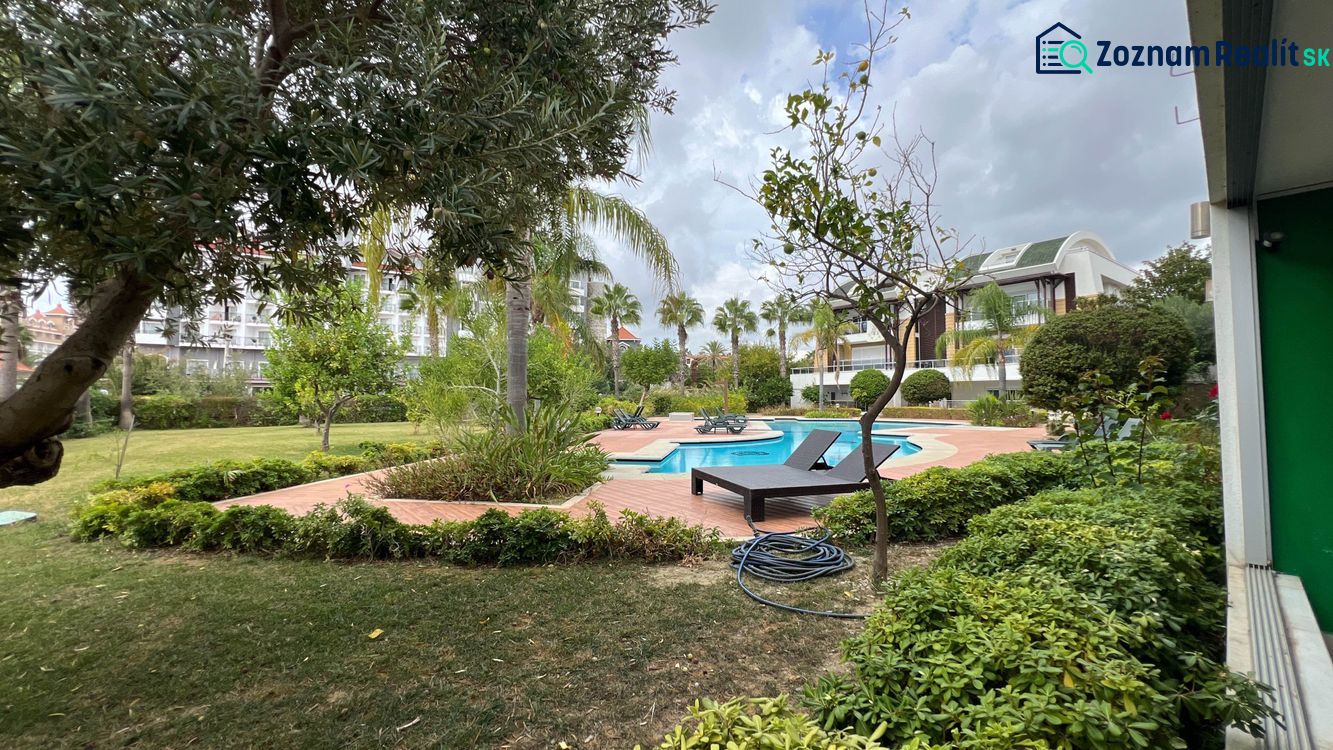 A garden with a pool and loungers in the Holiday Apartment in the Kumköy area of Side.