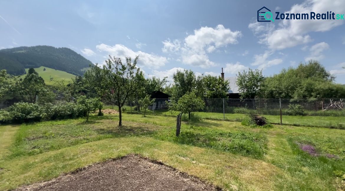 A garden at a family house in Liptovská Lúžna with fruit trees and a mountain view.