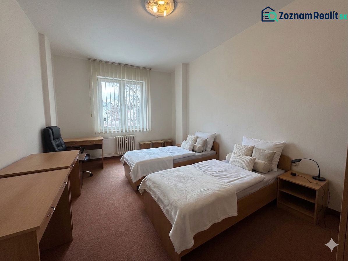 A bedroom in a 3-room apartment with separate beds and a work desk.