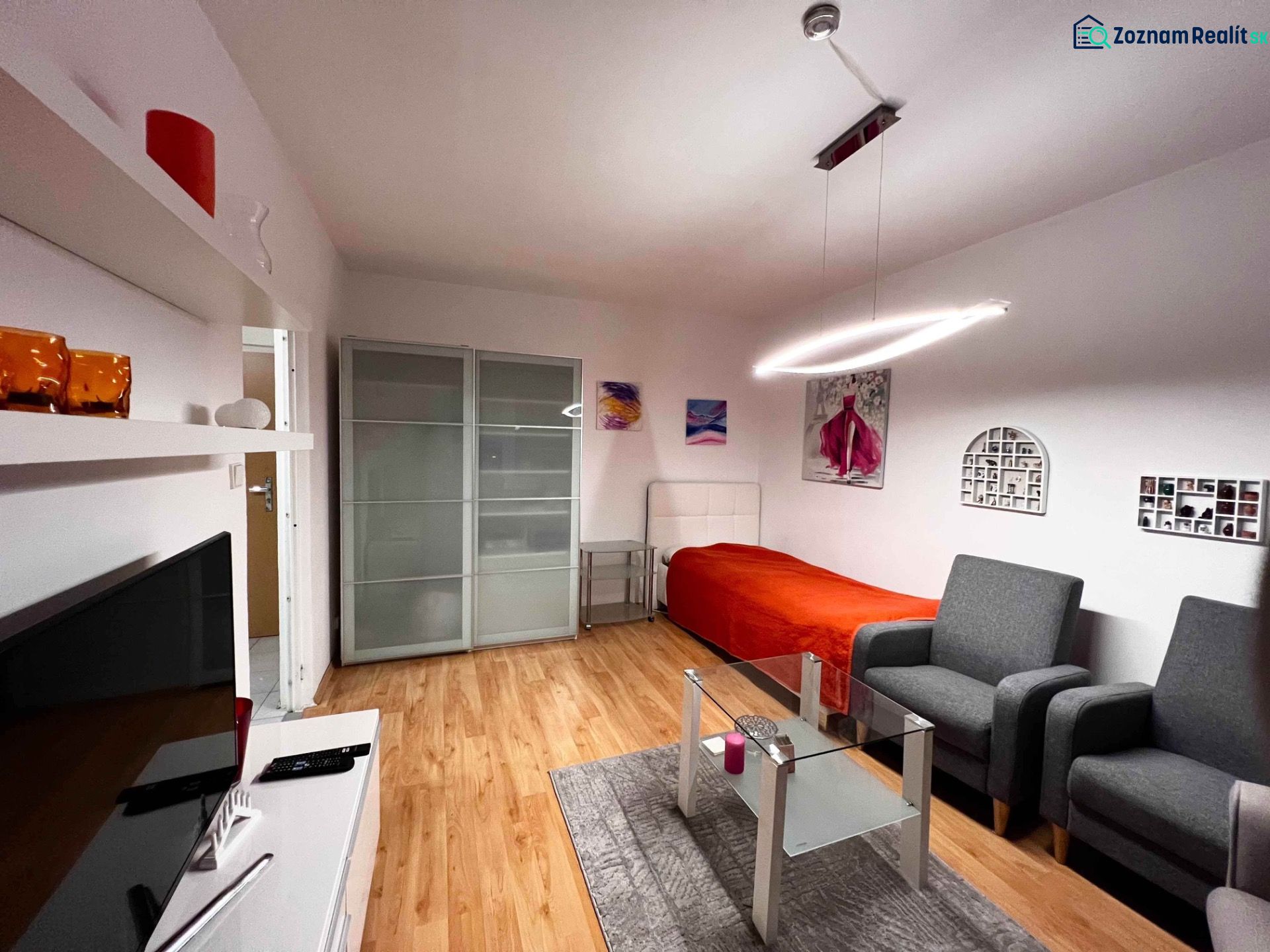 Living room in a one-room apartment with a wooden decor floor, modern lighting, seating.