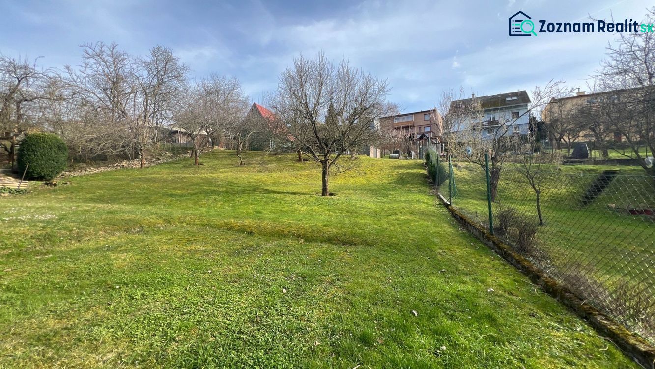 The garden of a family house on Makovického Street in Ružomberok with trees and a lawn.