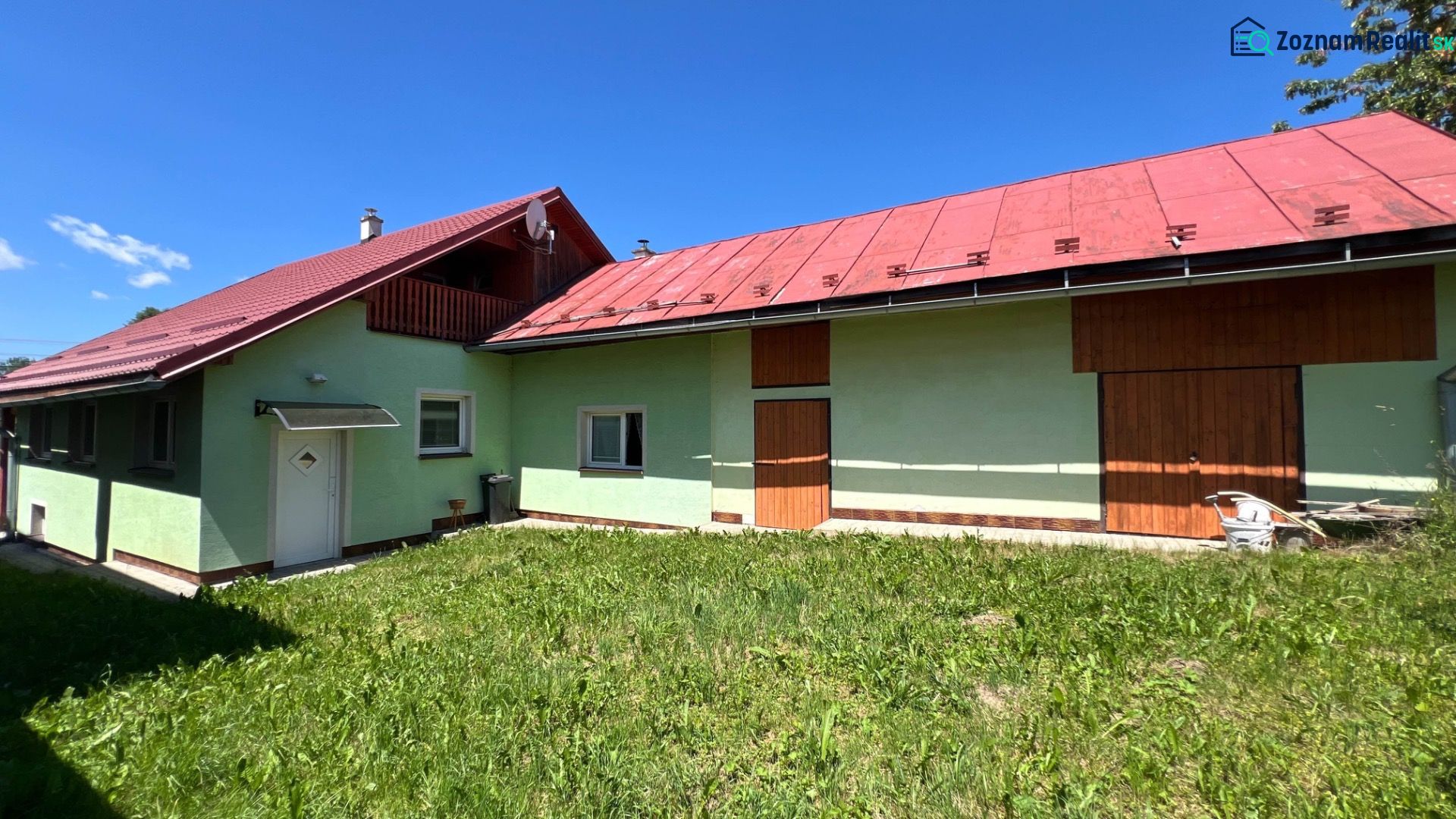 A family house in Polomka with colorful facades and a red roof against the backdrop of a blue sky.