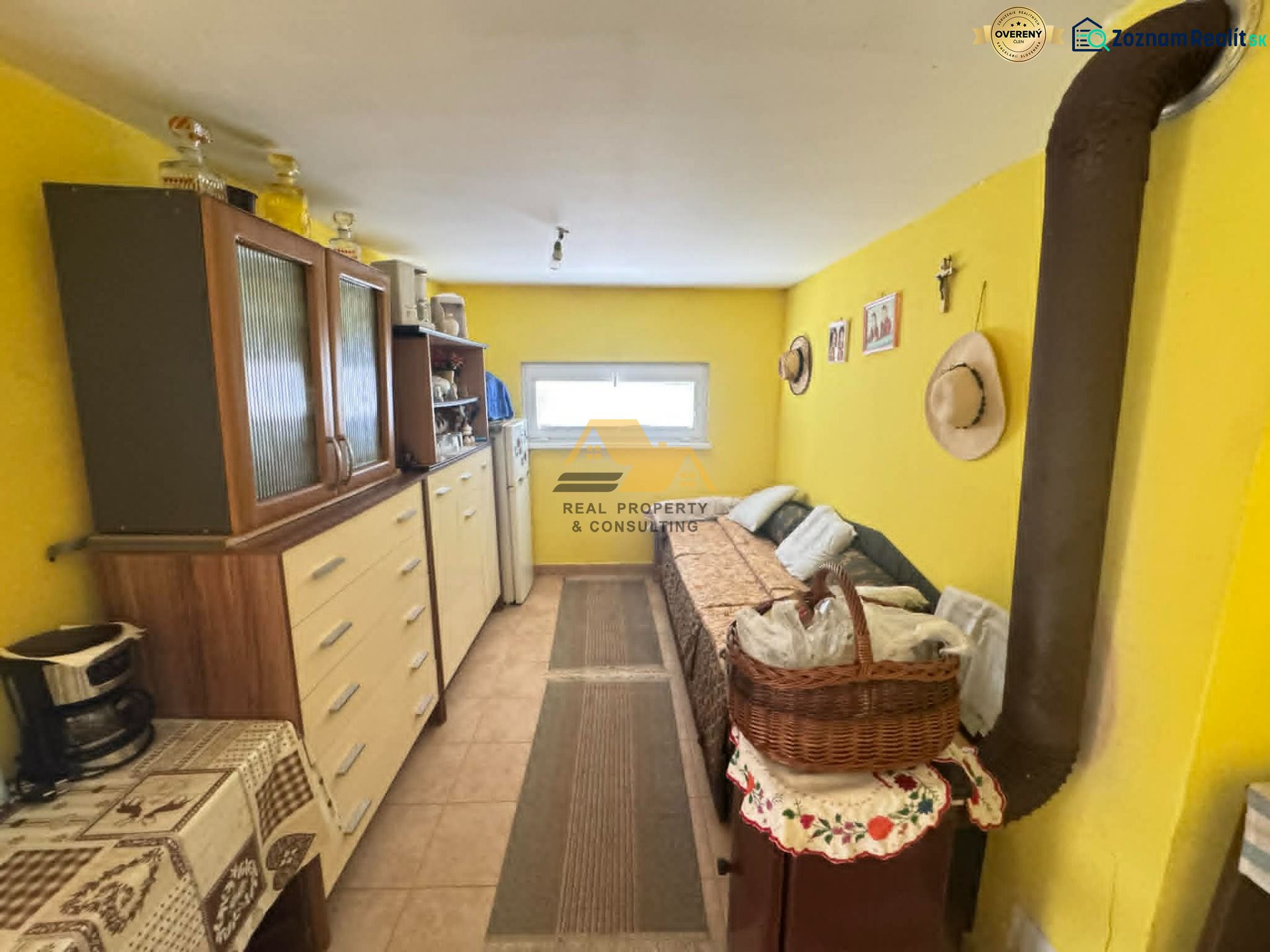 Interior of a cabin with a wooden wardrobe and a carpet on a wood-patterned floor.