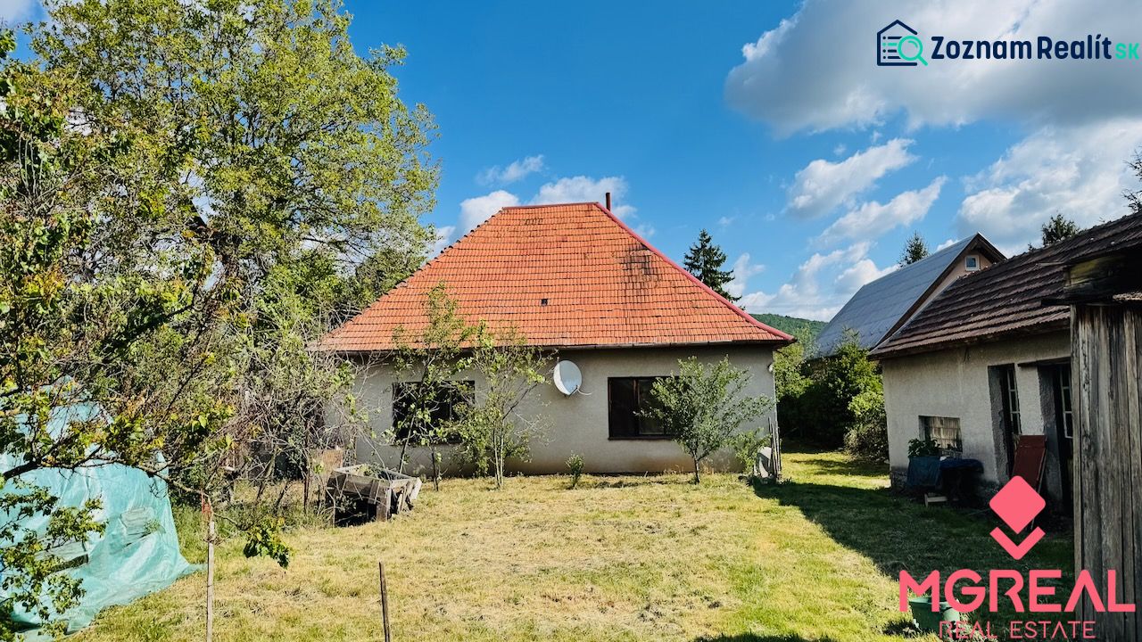 A family house in Pažiť with a red roof in a landscaped garden.