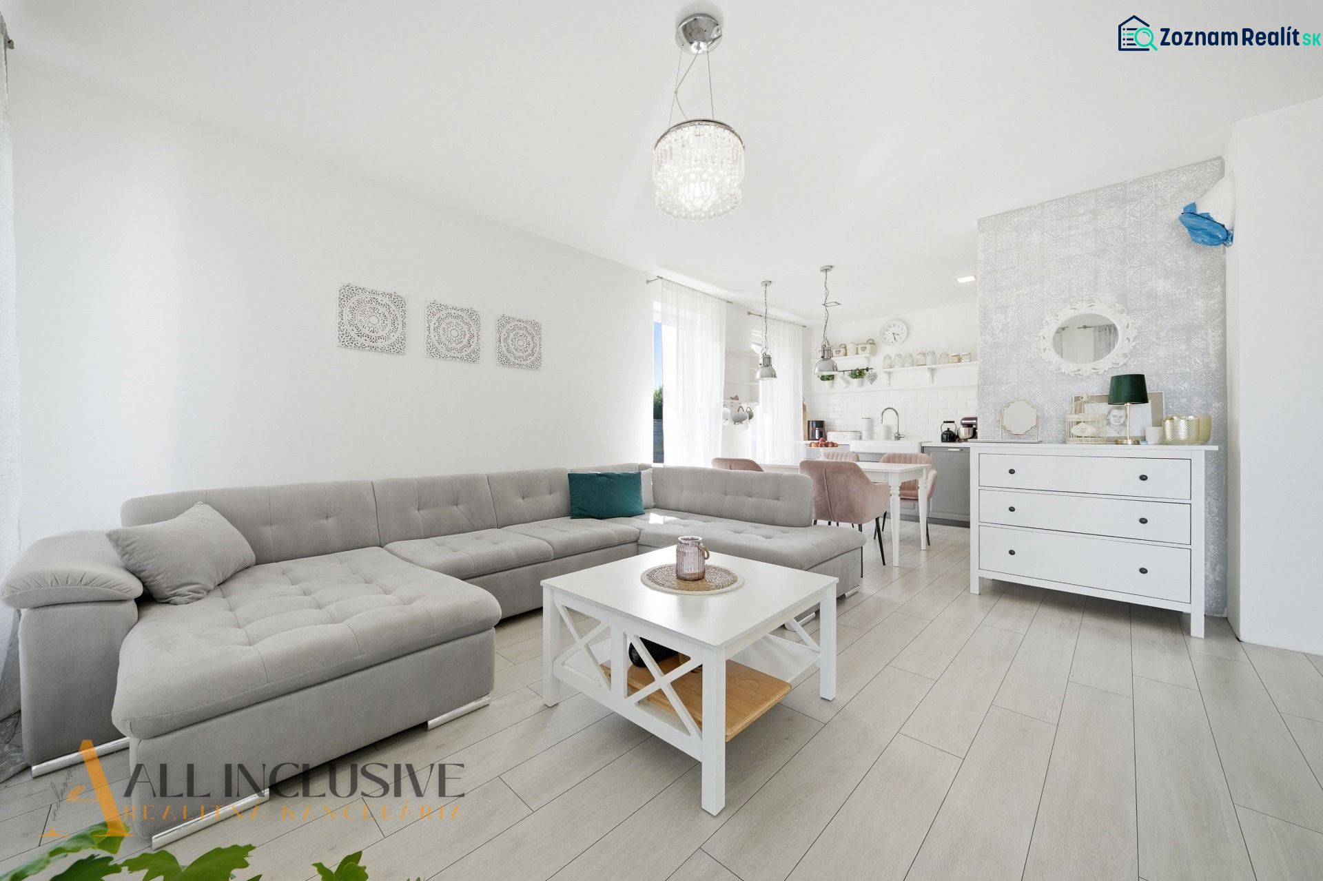 Living room with a corner sofa, table, and wooden decor flooring in a family house.
