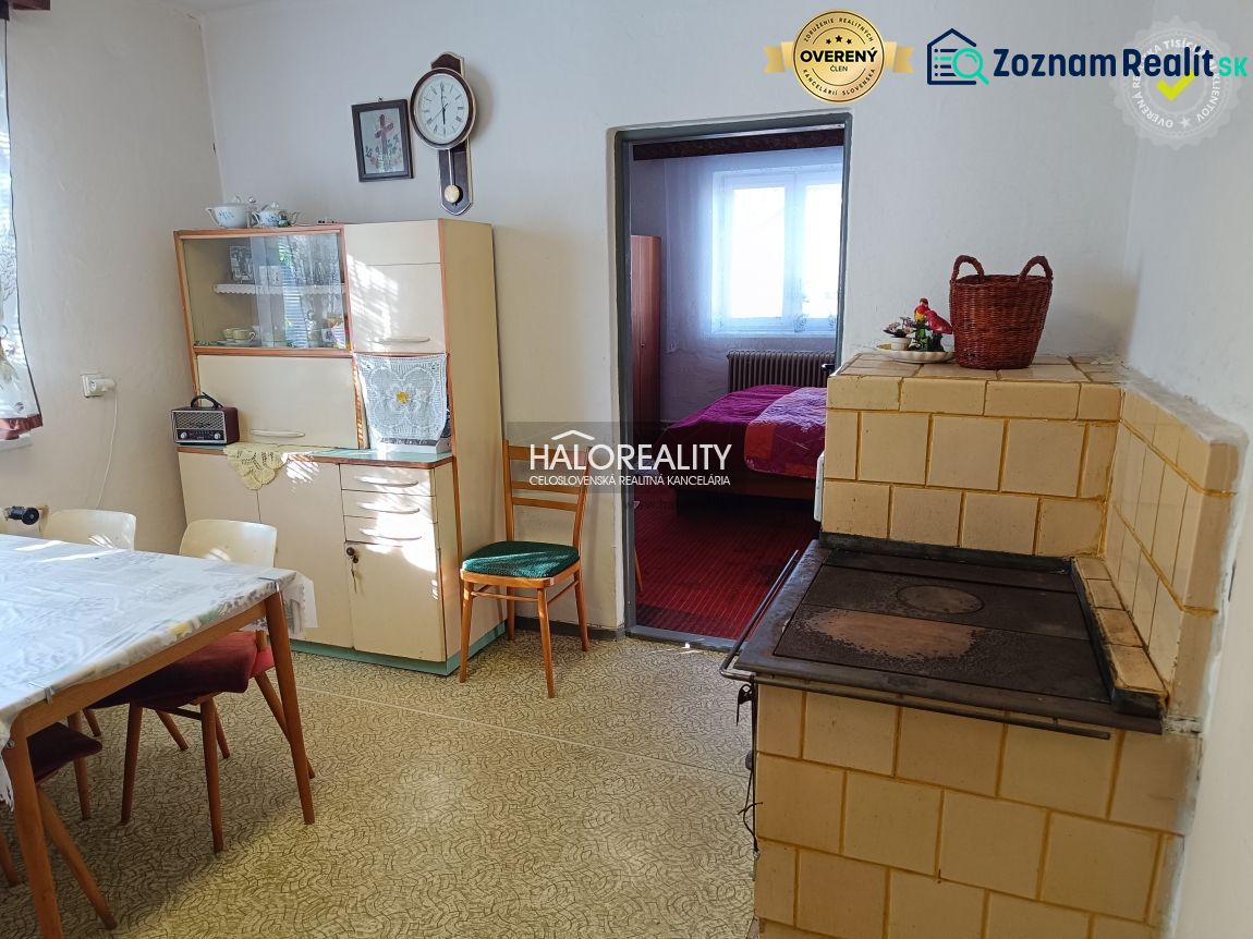 Kitchen in a family house with a stove, dining table, and display cabinet.