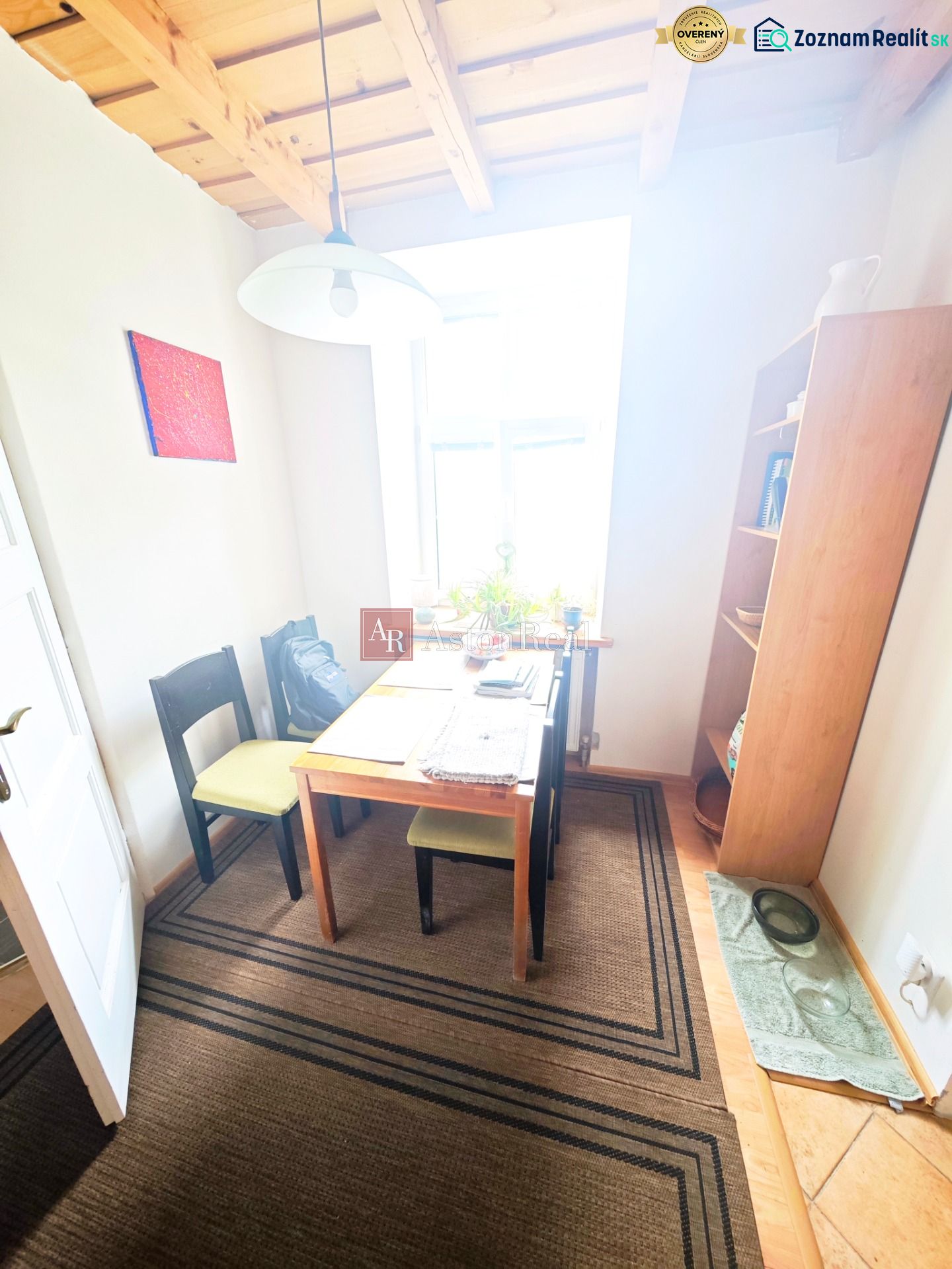 Dining area with a table, chairs, and shelves in a 2-room apartment.