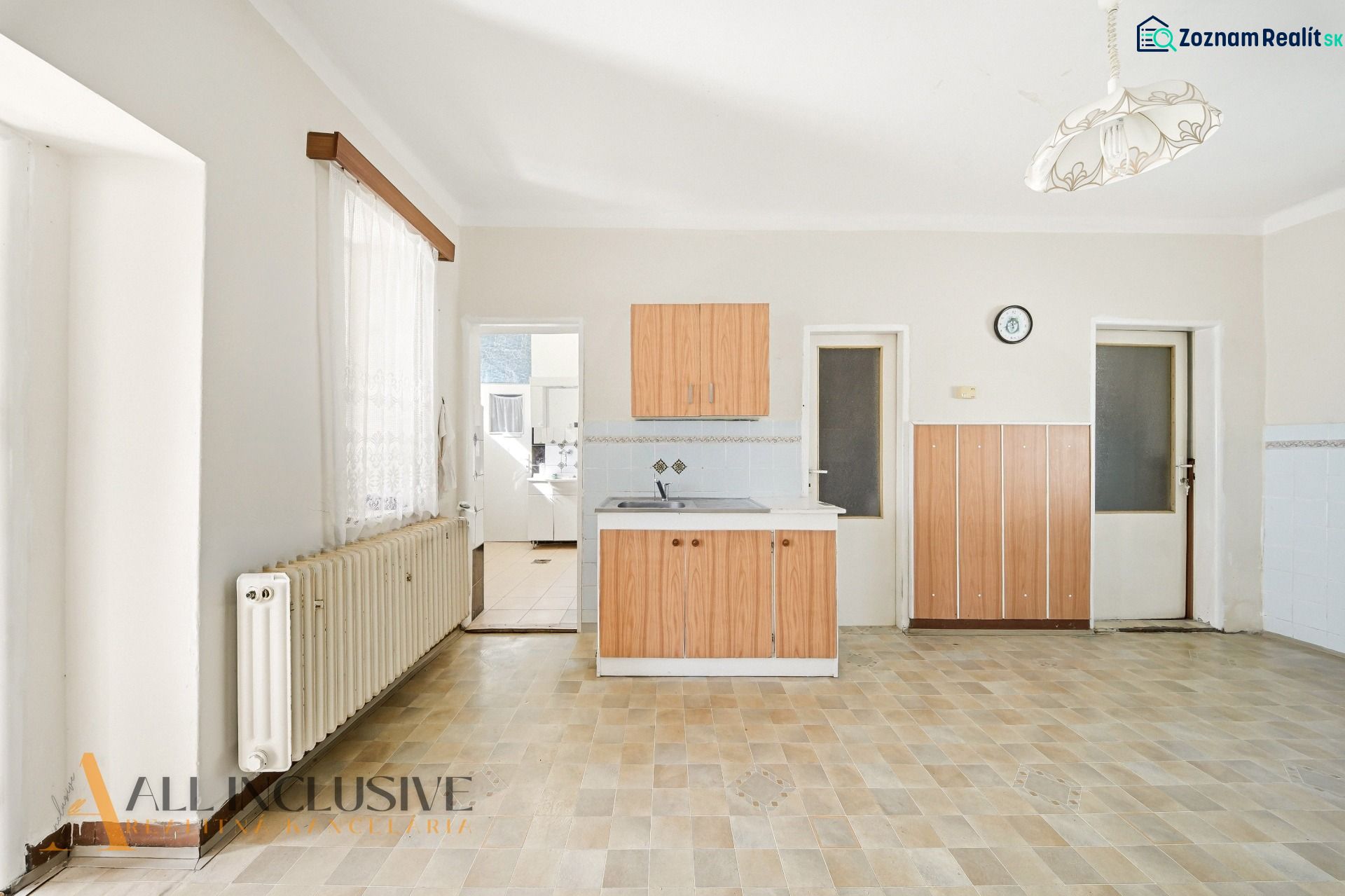 A kitchen in a family house with a wooden decor floor and wooden cabinets.