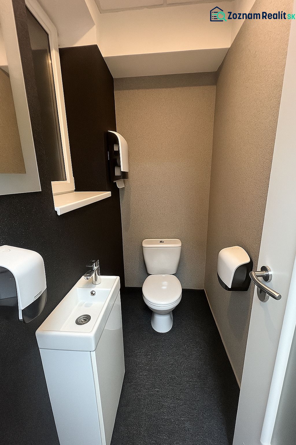 A toilet with a sink and a paper dispenser in offices.