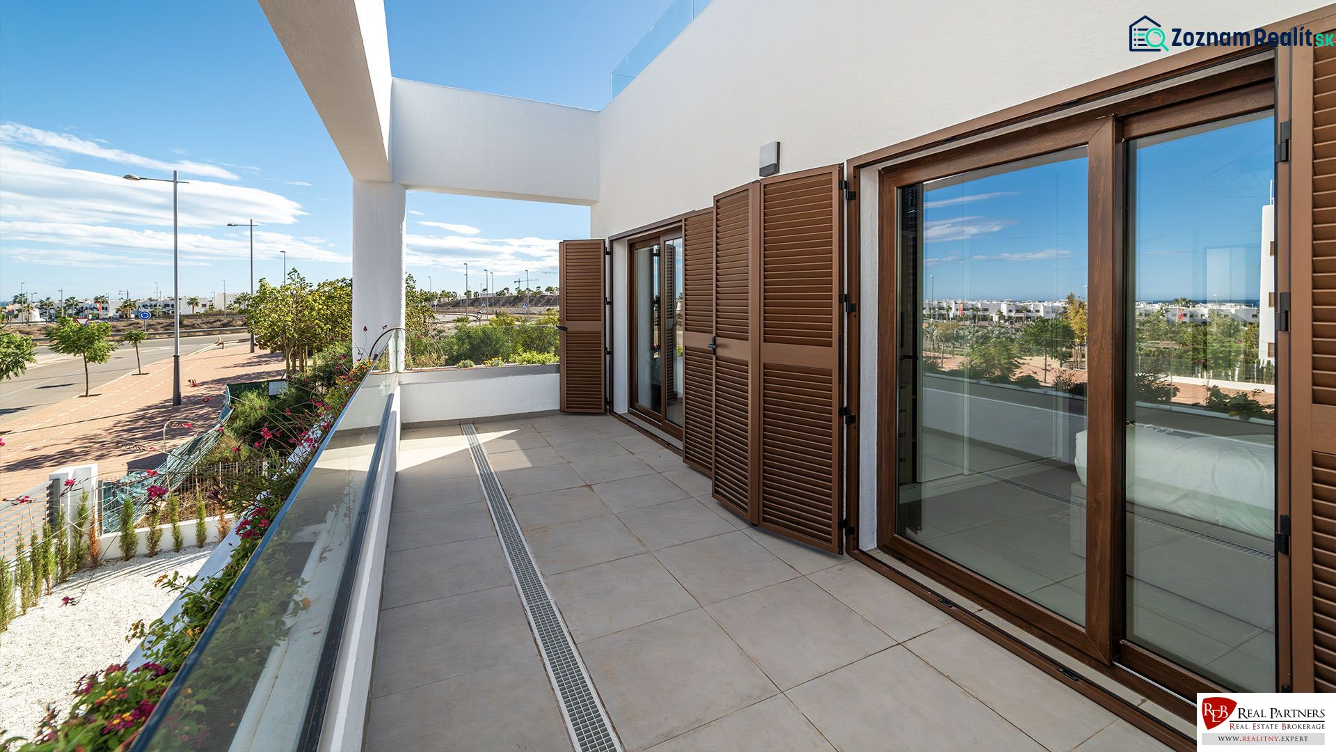 Terrace of a 2-bedroom apartment in Pulpí with a view of the street and greenery.