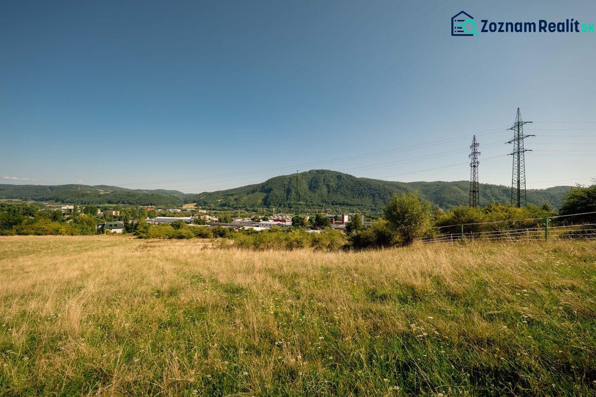 A landscape with a grassy plot and electric poles on Partizánska Street, Banská Bystrica. Plots - residential.