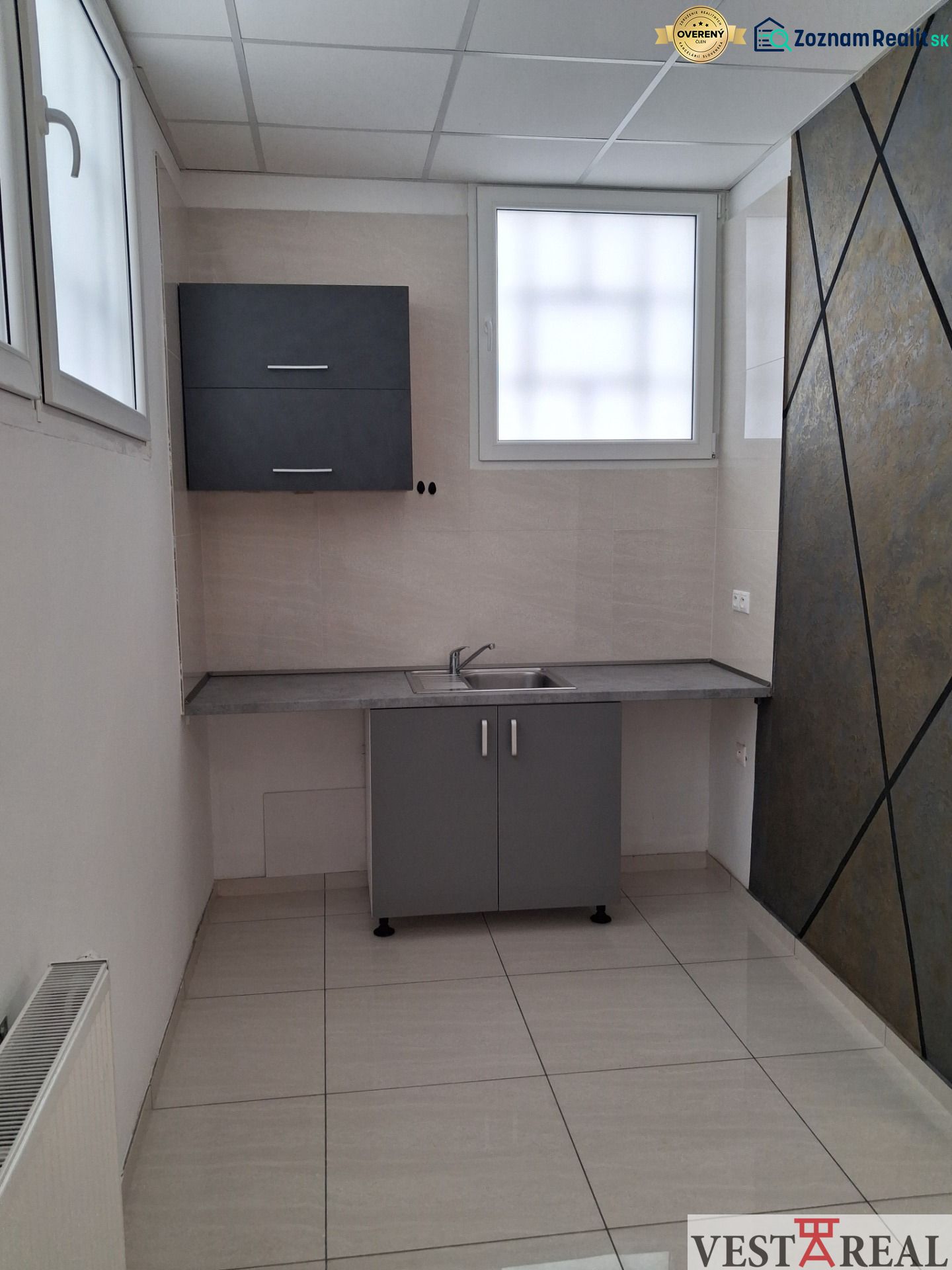 Offices with a kitchenette, tiled flooring, and a gray cabinet, suitable for a work environment.