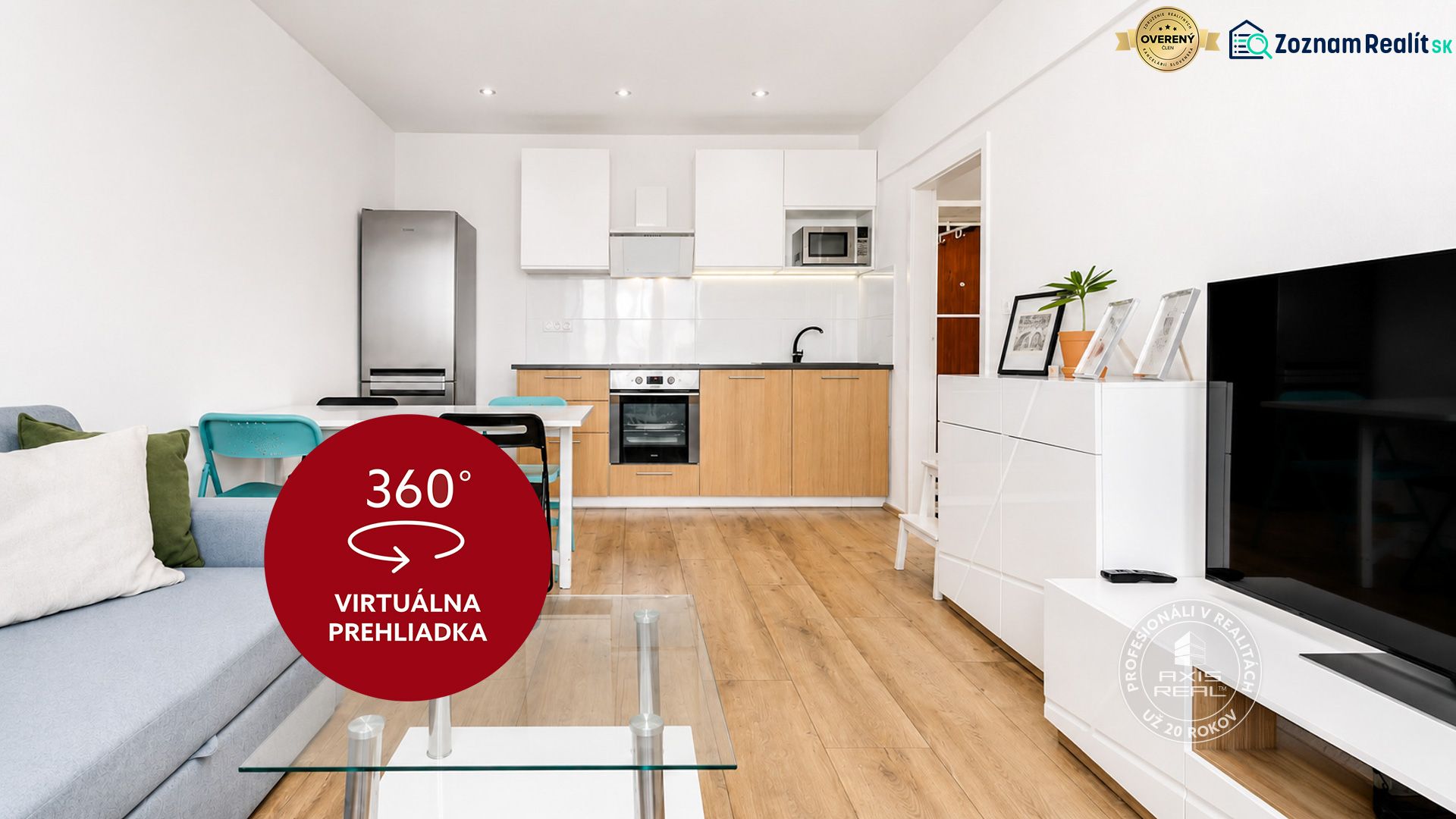 Living room with kitchen in a 2-room apartment with a wooden decor floor and a gray sofa.