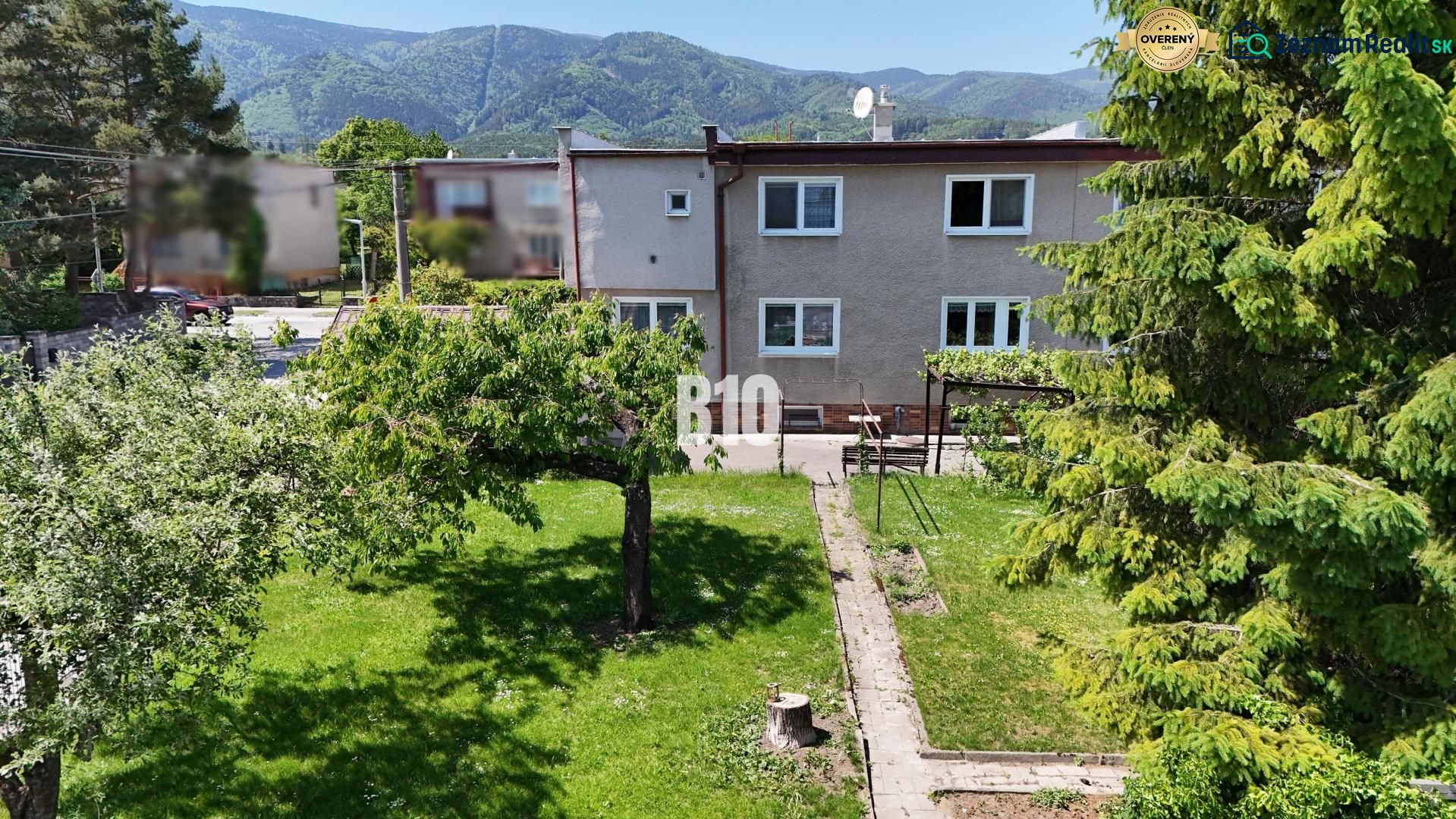 A family house in Martin with a spacious garden and mountains in the background.