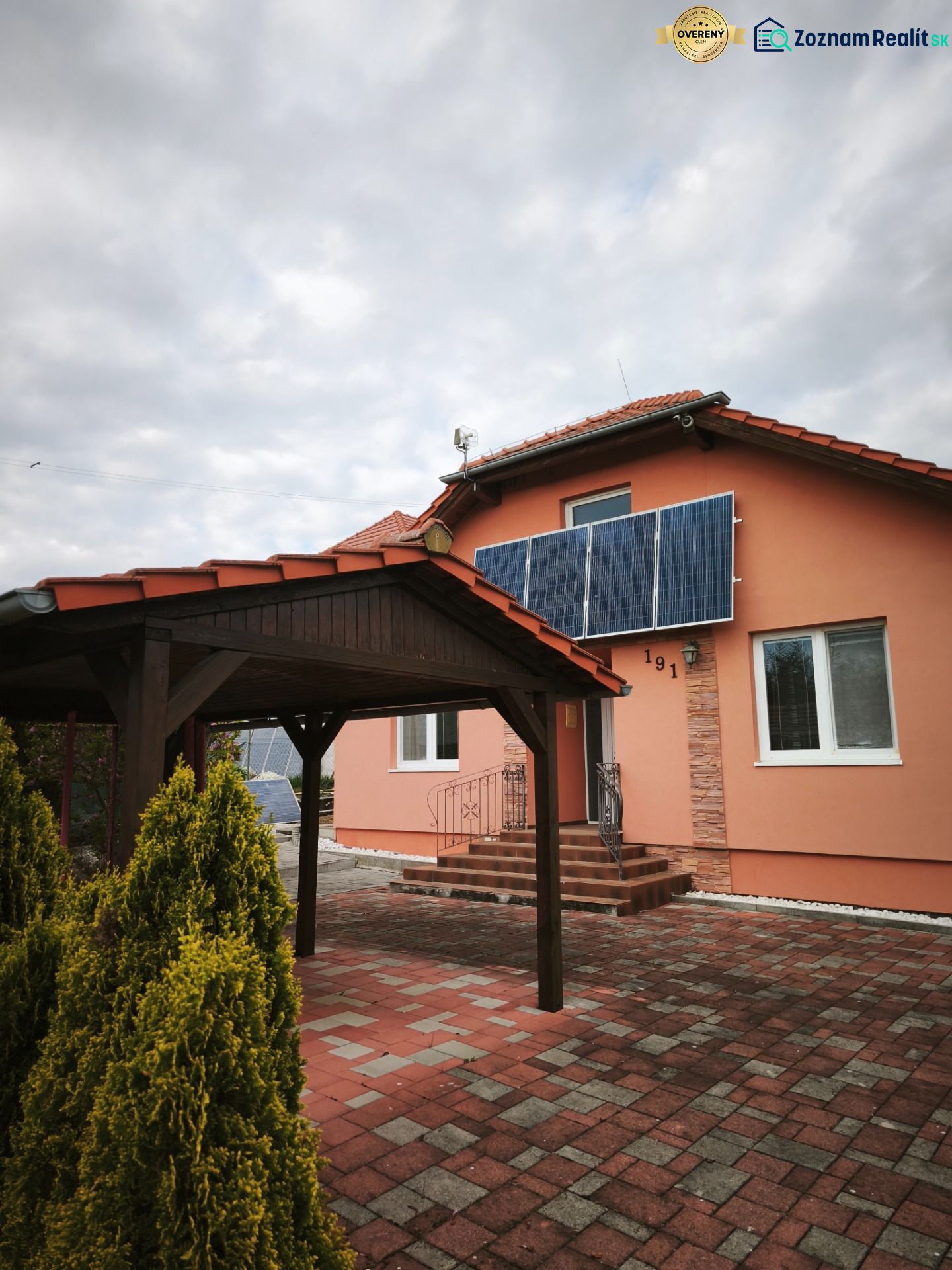 A family house in Martin nad Žitavou with solar panels and a gazebo on the terrace.