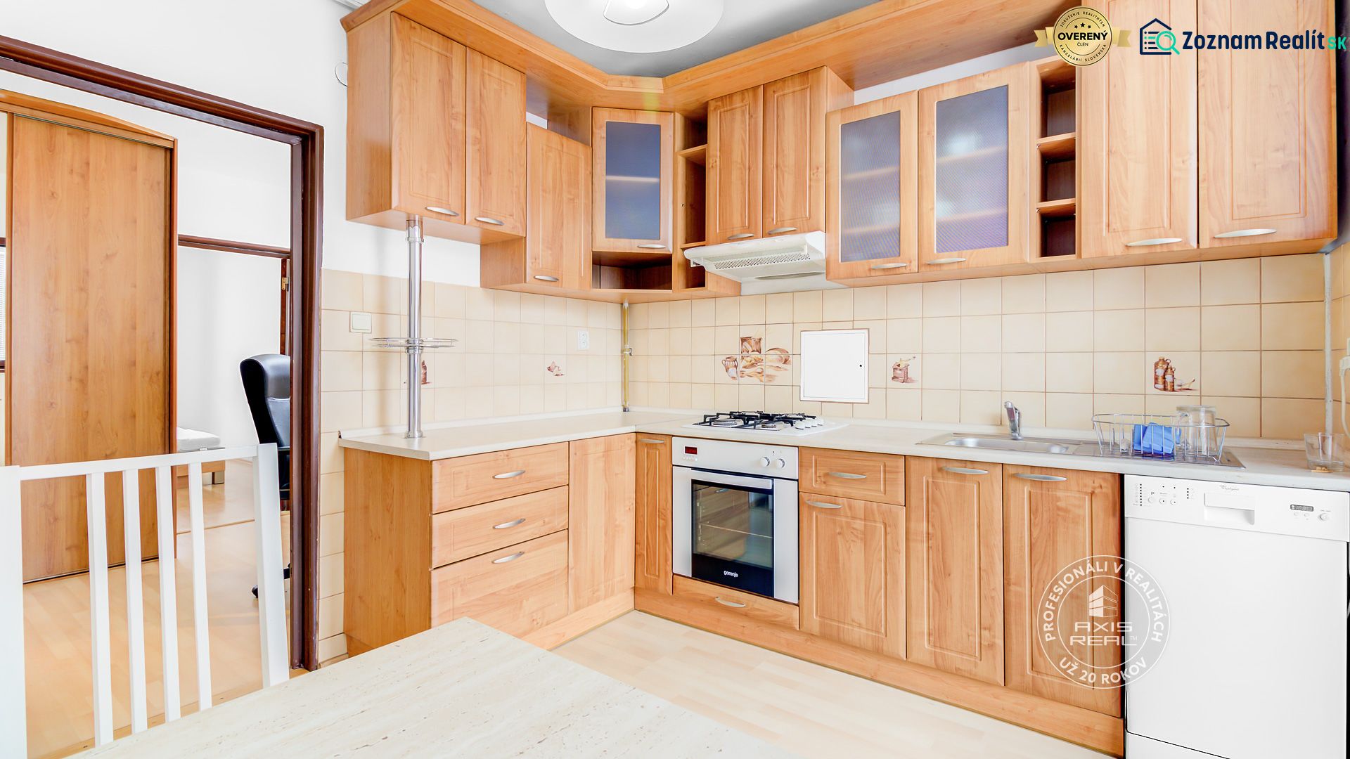 A kitchen in a 2-room apartment with a wooden decor floor and wooden cabinets.