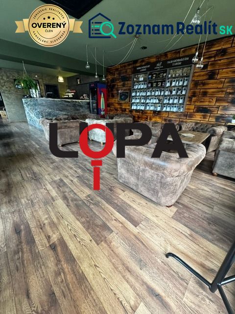 Interior of commercial spaces with comfortable seating, walls with wooden decor, and flooring with wooden decor.