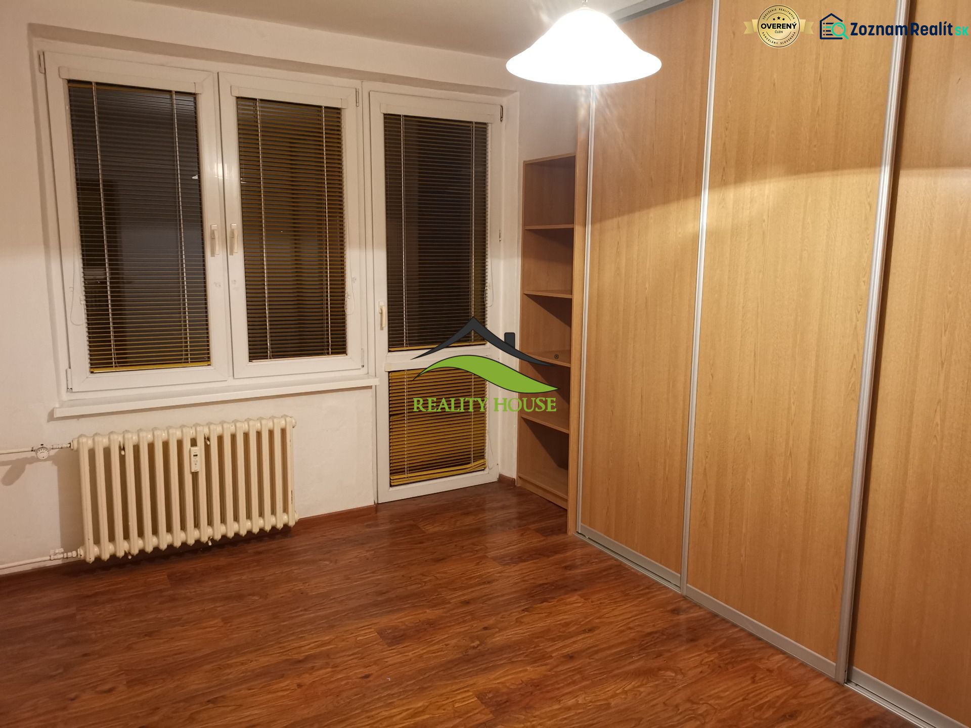 A room with a wooden floor decor and a large built-in wardrobe in a 3-room apartment.