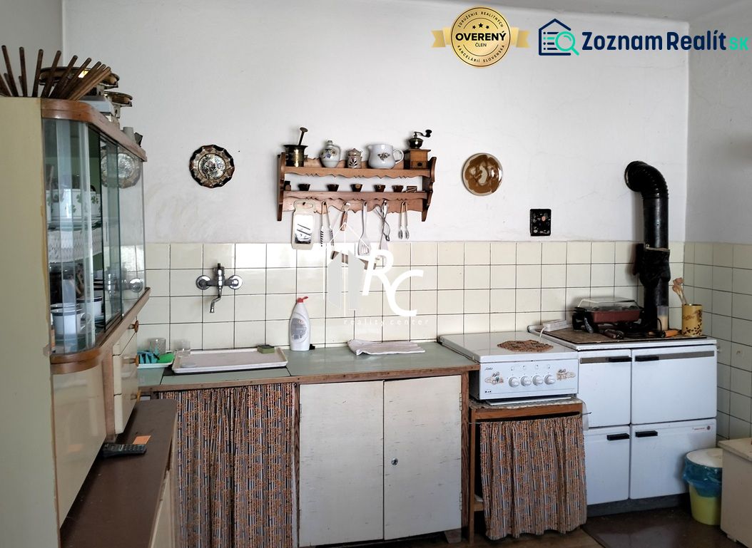 A kitchen in a family house with rustic cabinets and a classic stove.