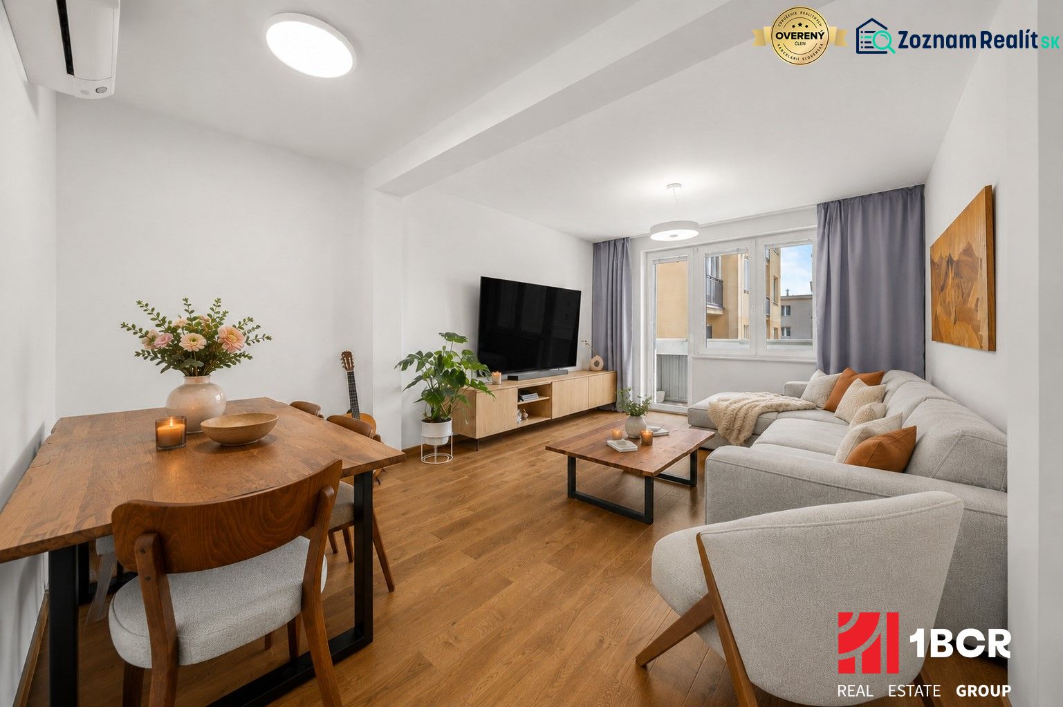 Living room in a 3-room apartment with a wooden decor floor, light furniture, and decorations.