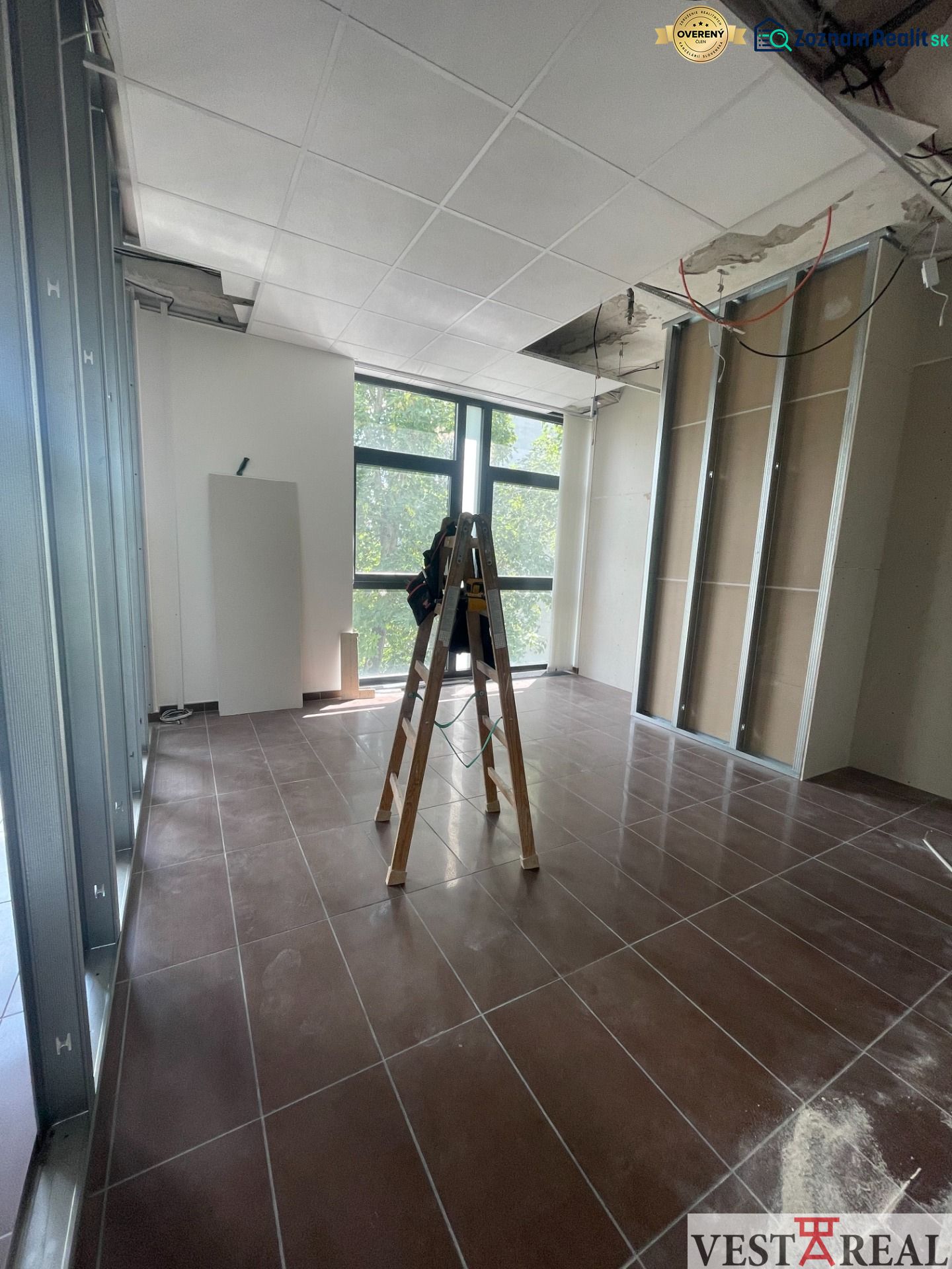 Offices with a ladder and an unfinished ceiling, floor with wood decor.