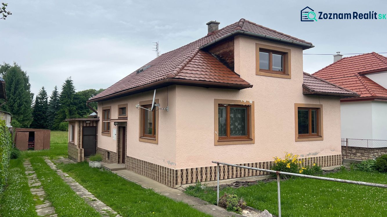 A family house in Ľubeľa with a red roof, a lawn yard, and an outdoor storage.