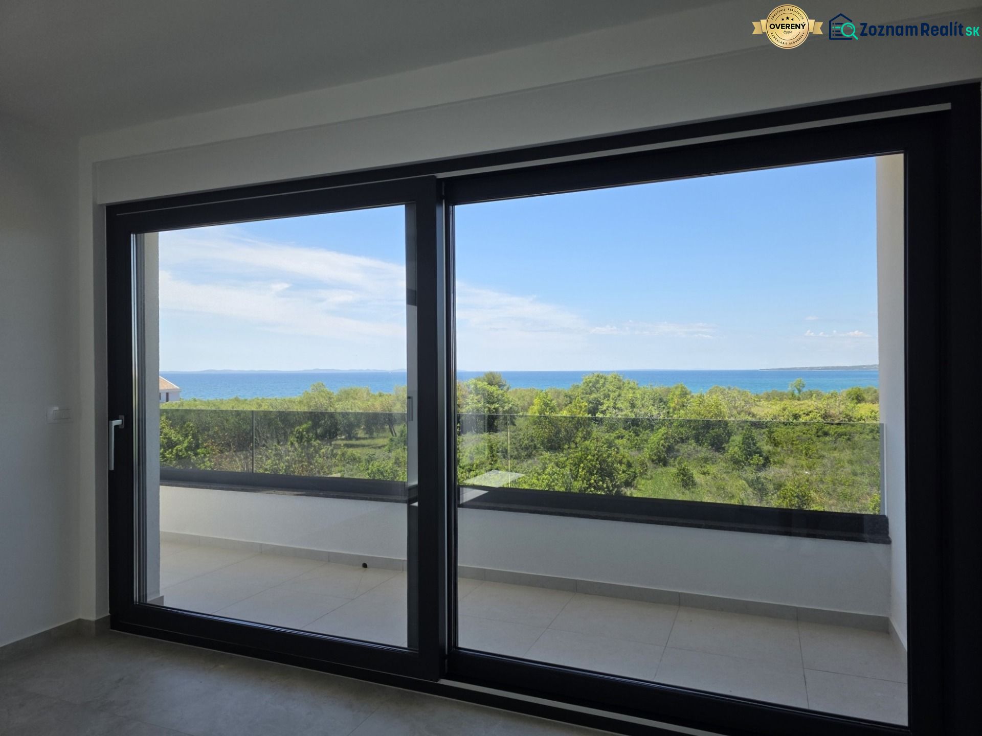 The large window in the 4-room apartment offers a panoramic view of nature and the sea.