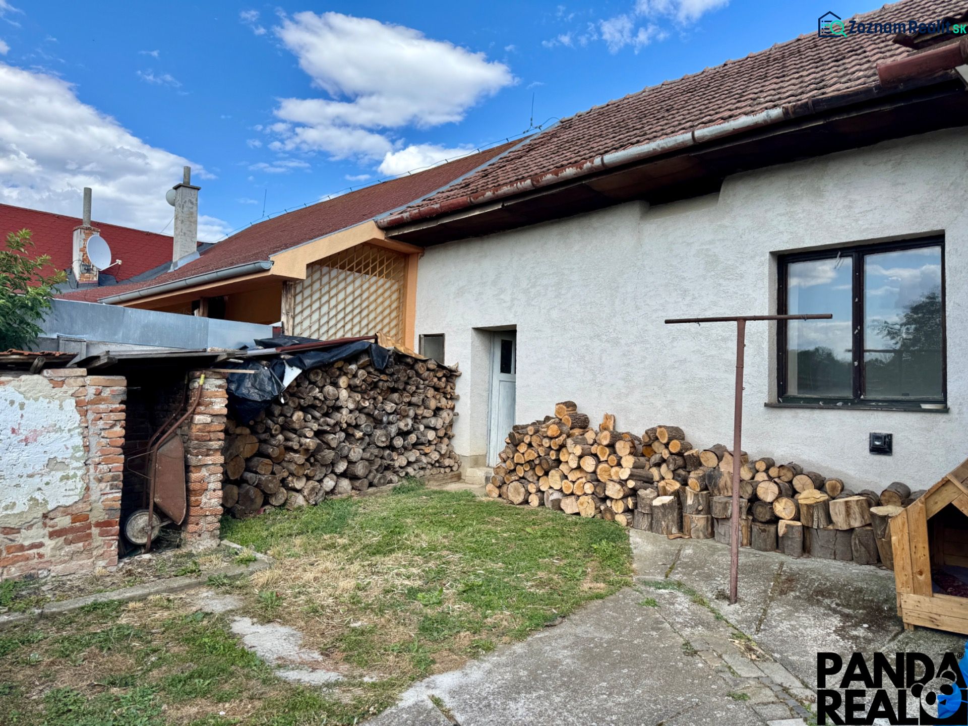A family house in Horné Obdokovce with wood stored in the yard and a shelter.