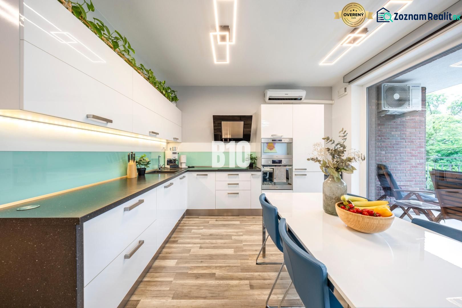 A kitchen with white cabinets and a wood-patterned floor in a 3-room apartment.