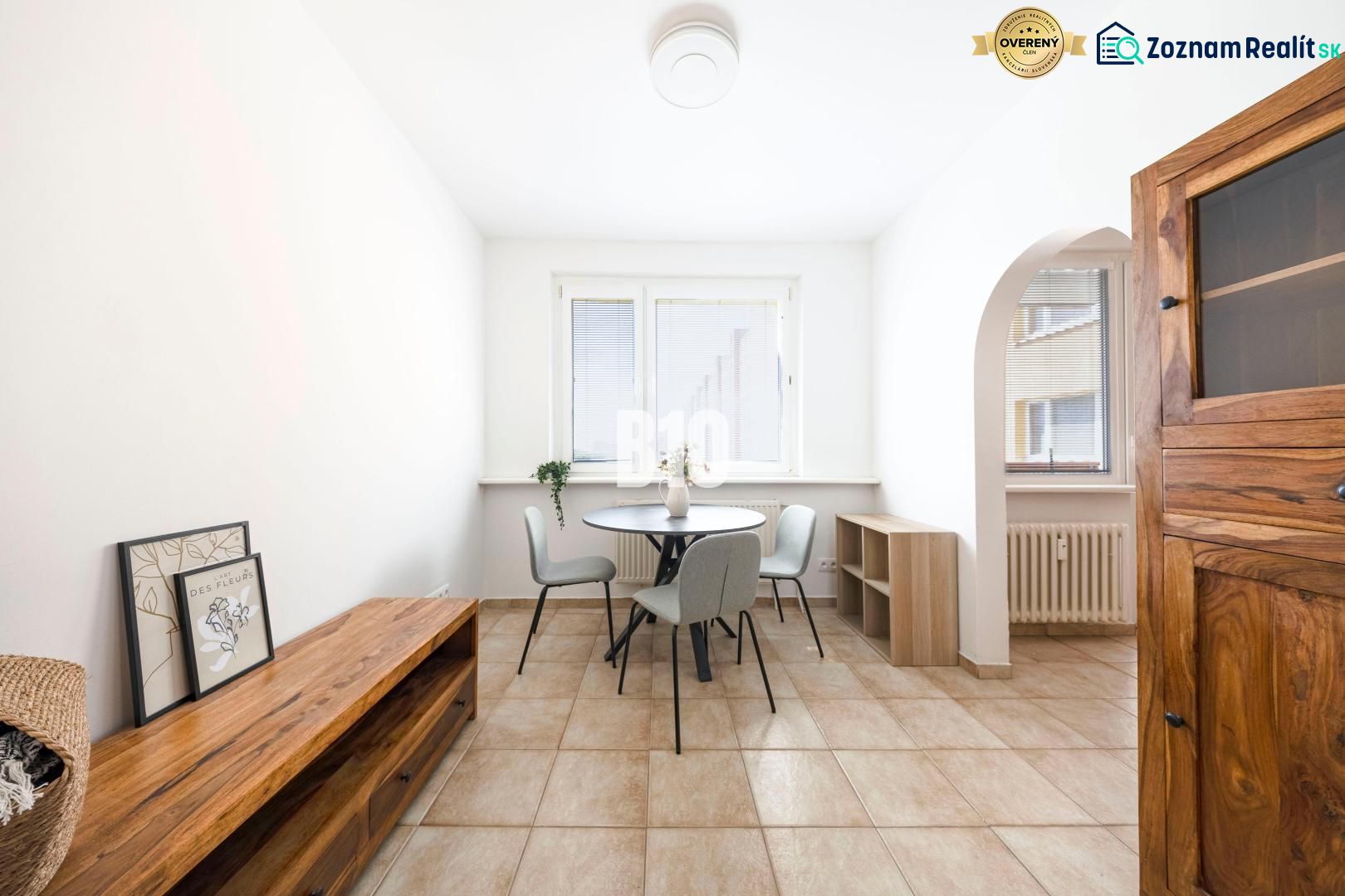 Dining area with a table and chairs in a 3-room apartment, tiled floor.