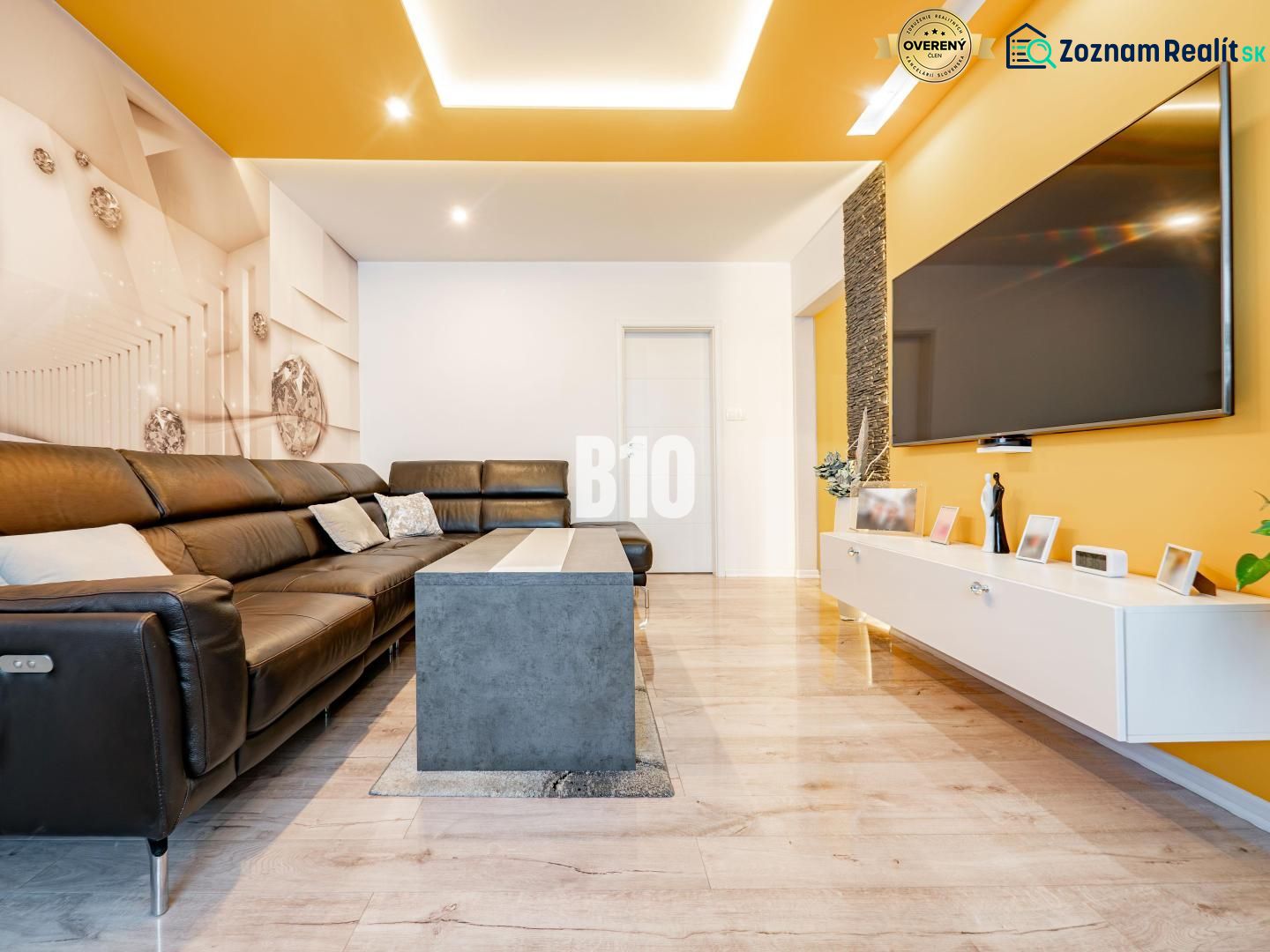 Living room in a 3-room apartment with a leather sofa set and a floor with a wood decor.