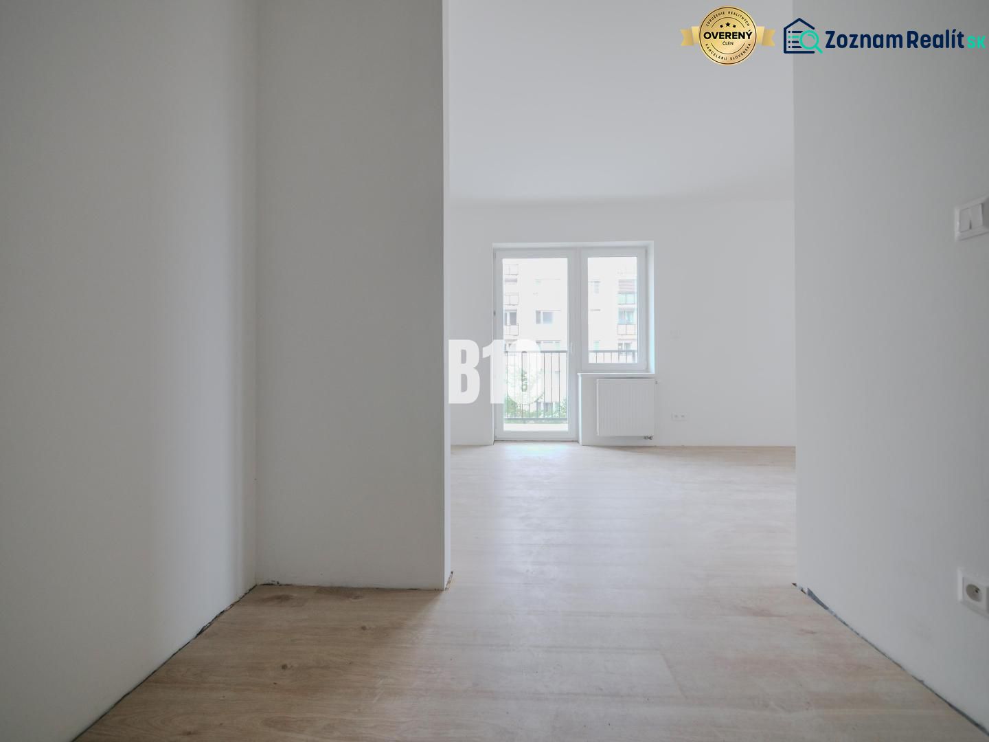 A bright room with a wooden decor floor in a studio apartment, window in the middle.