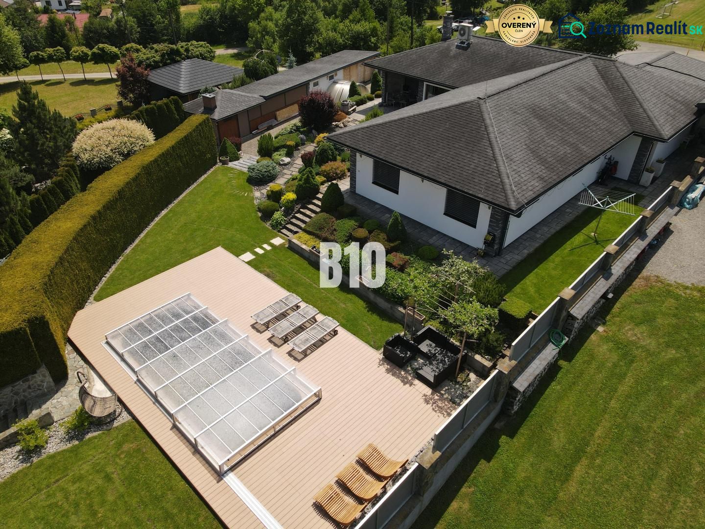 A family house in Súľov-Hradná with a terrace, swimming pool, and garden surrounded by greenery.