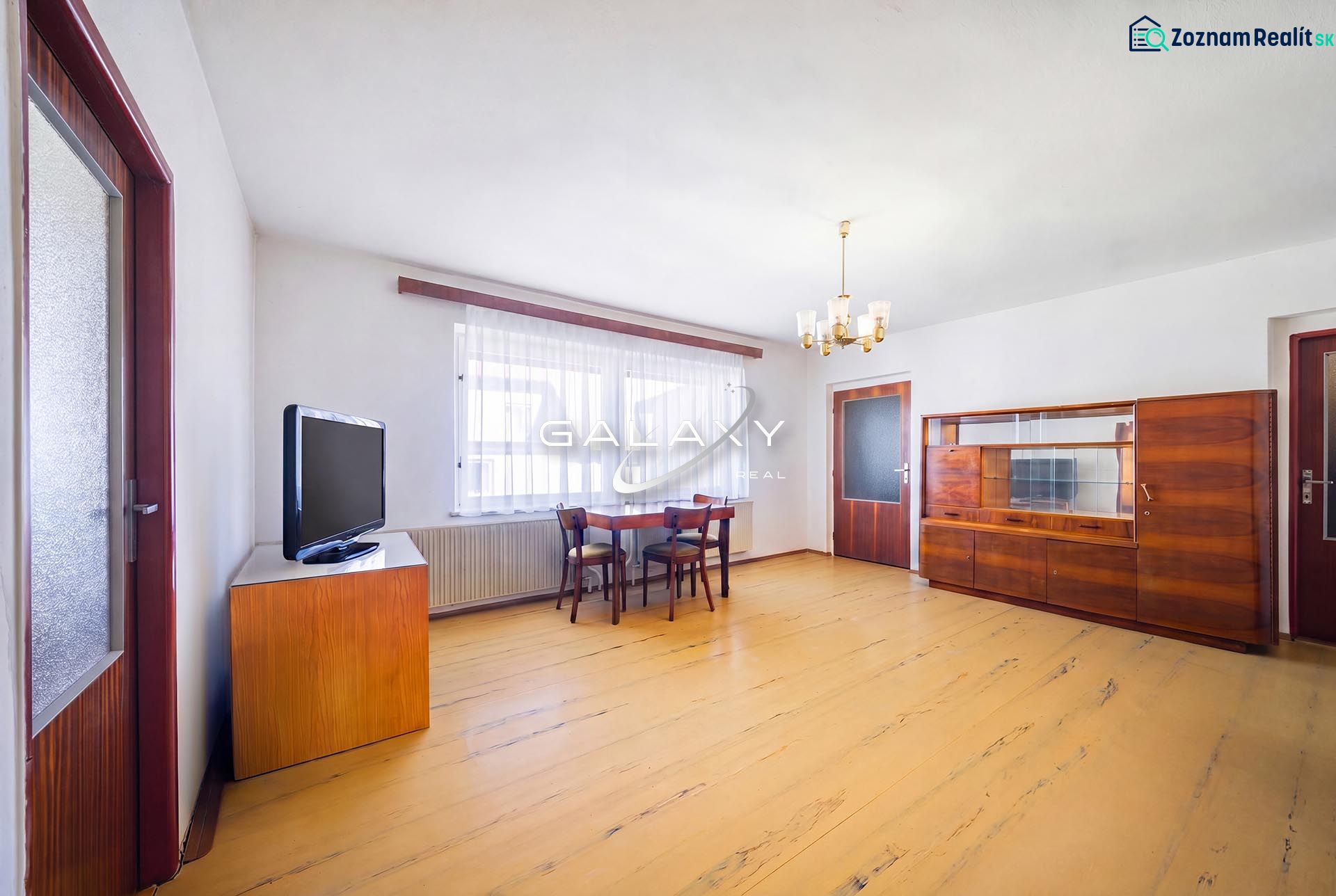 Living room in a family house with a wooden decor floor, furniture, and a television.