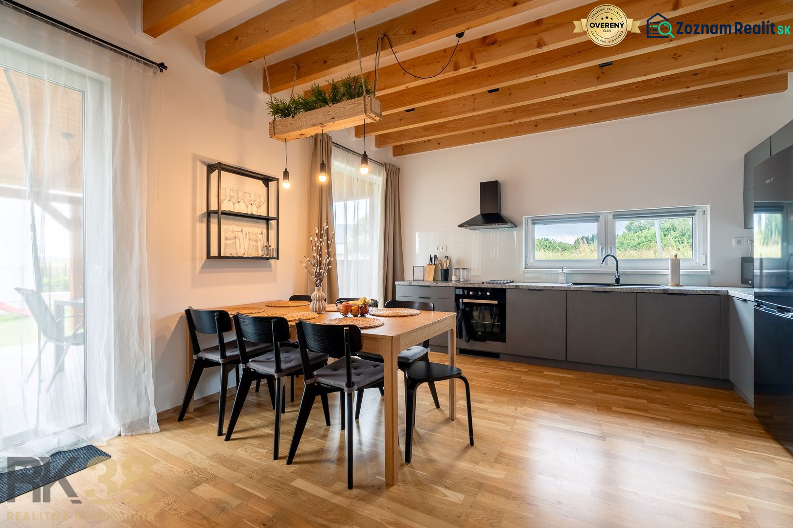 A kitchen in a 4-room apartment with a dining table and a wooden-patterned floor.