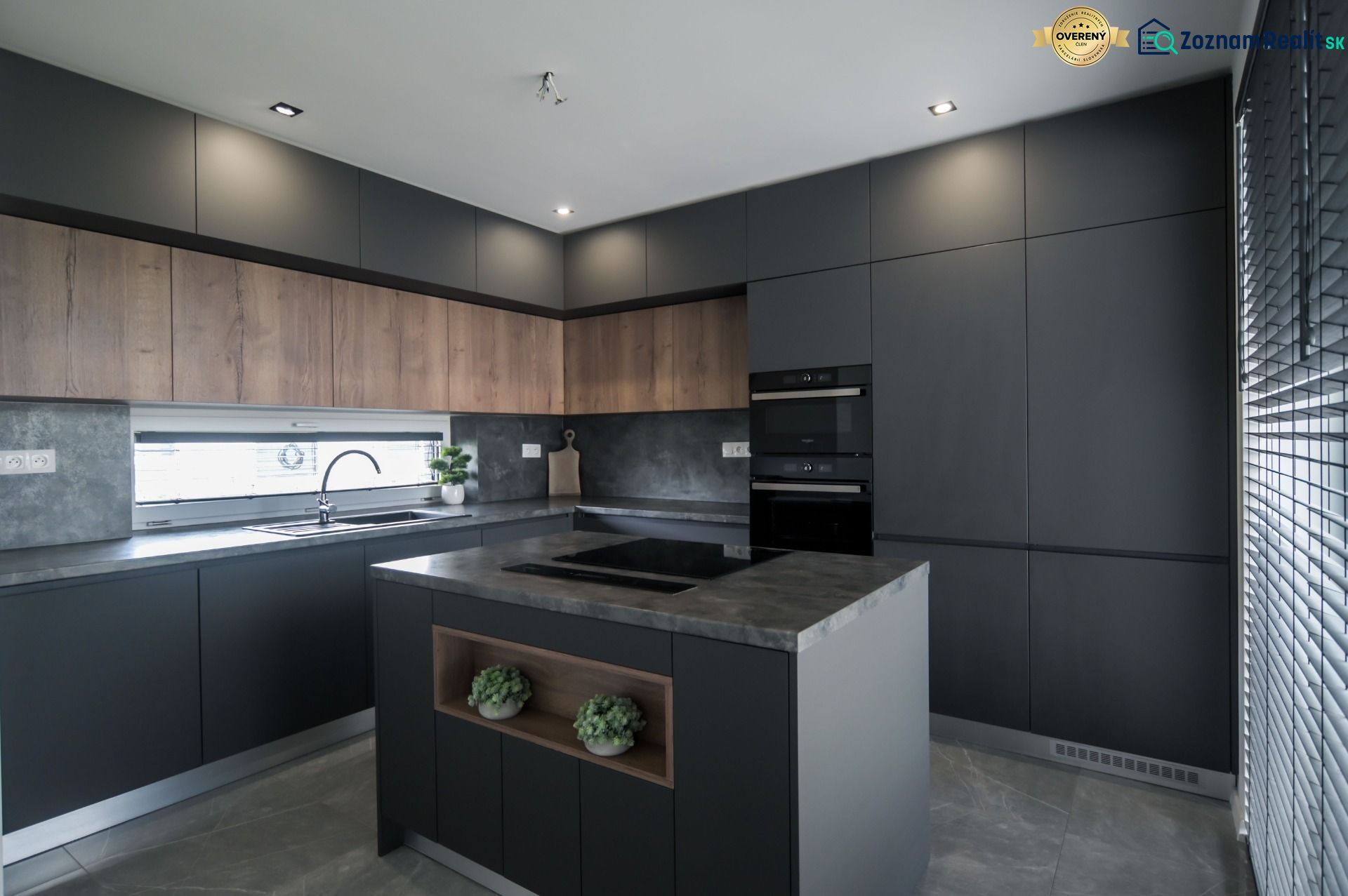 A kitchen with an island and a wooden decor floor in a family house.