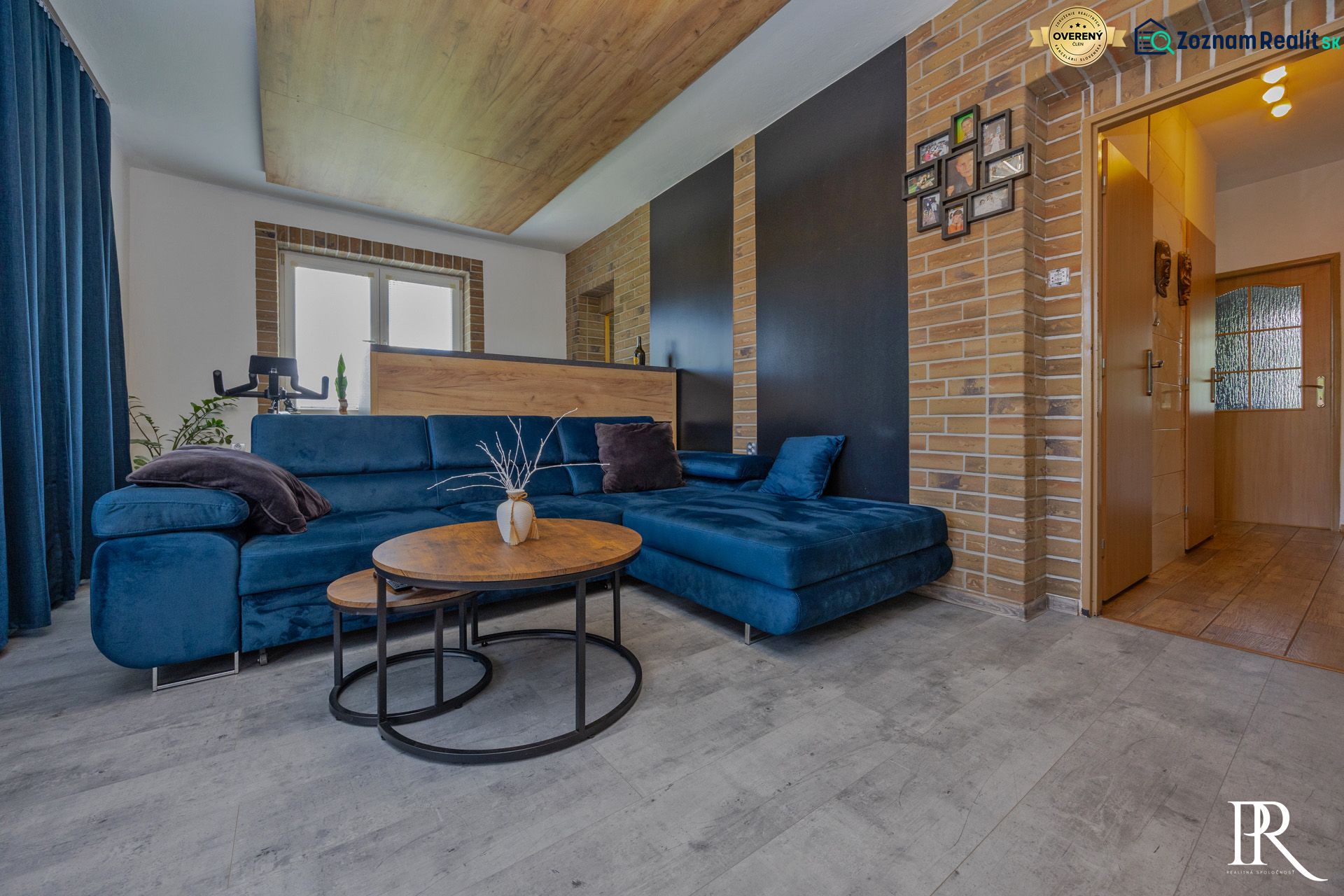 Blue sofa with round tables and wood-patterned flooring in a 3-room apartment.