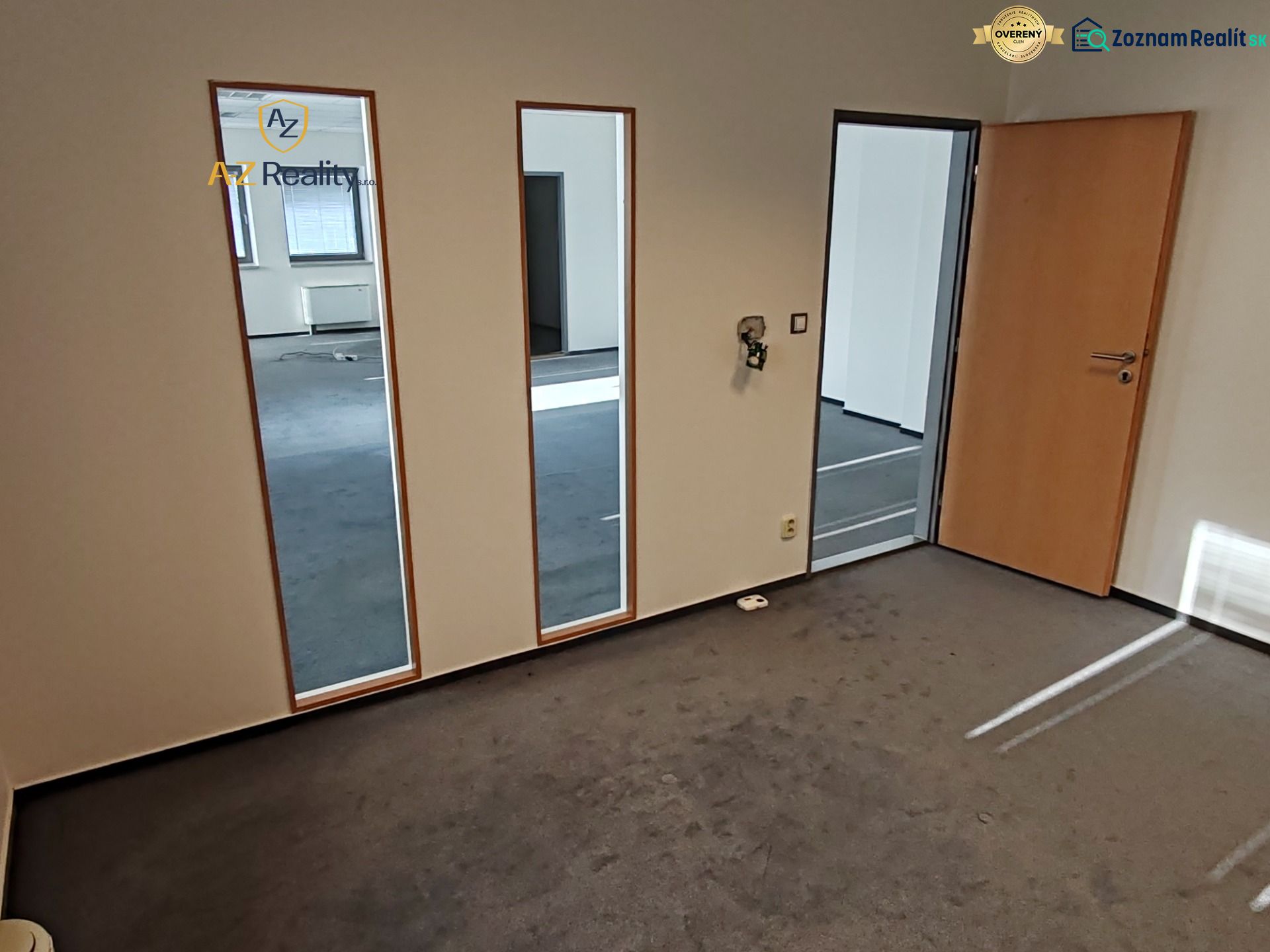 Offices with carpeted floors, a mirrored wall, and wooden doors.