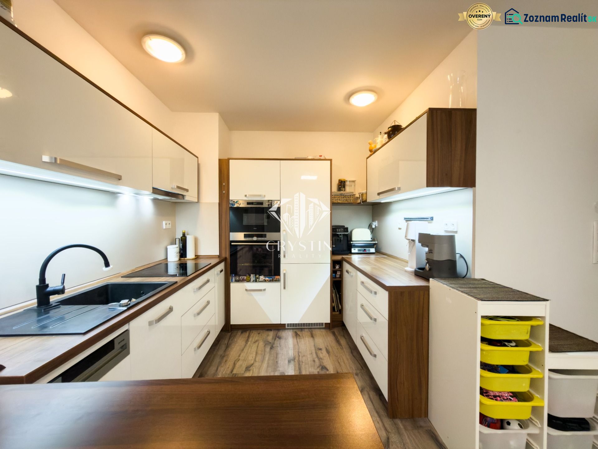 A kitchen in a 3-room apartment with a wooden decor and modern appliances.
