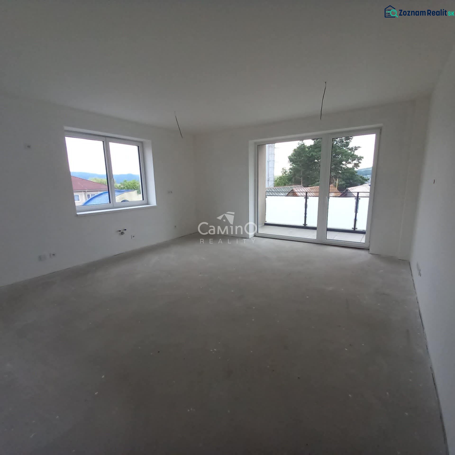 In the bright room of the 2-room apartment, there are large windows and balcony doors.