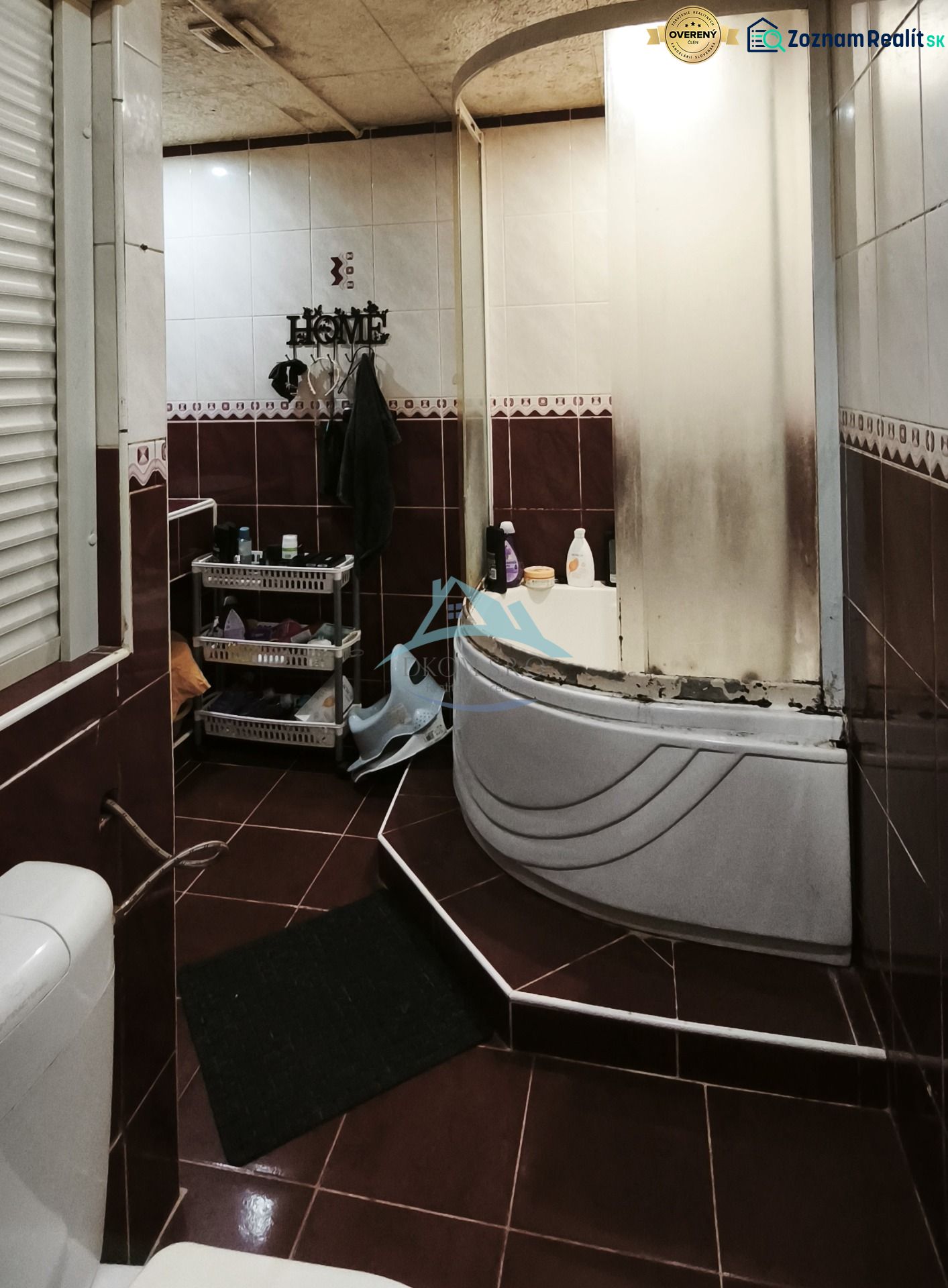 A bathroom with a bathtub, toilet, and storage shelves in a 2-room apartment.