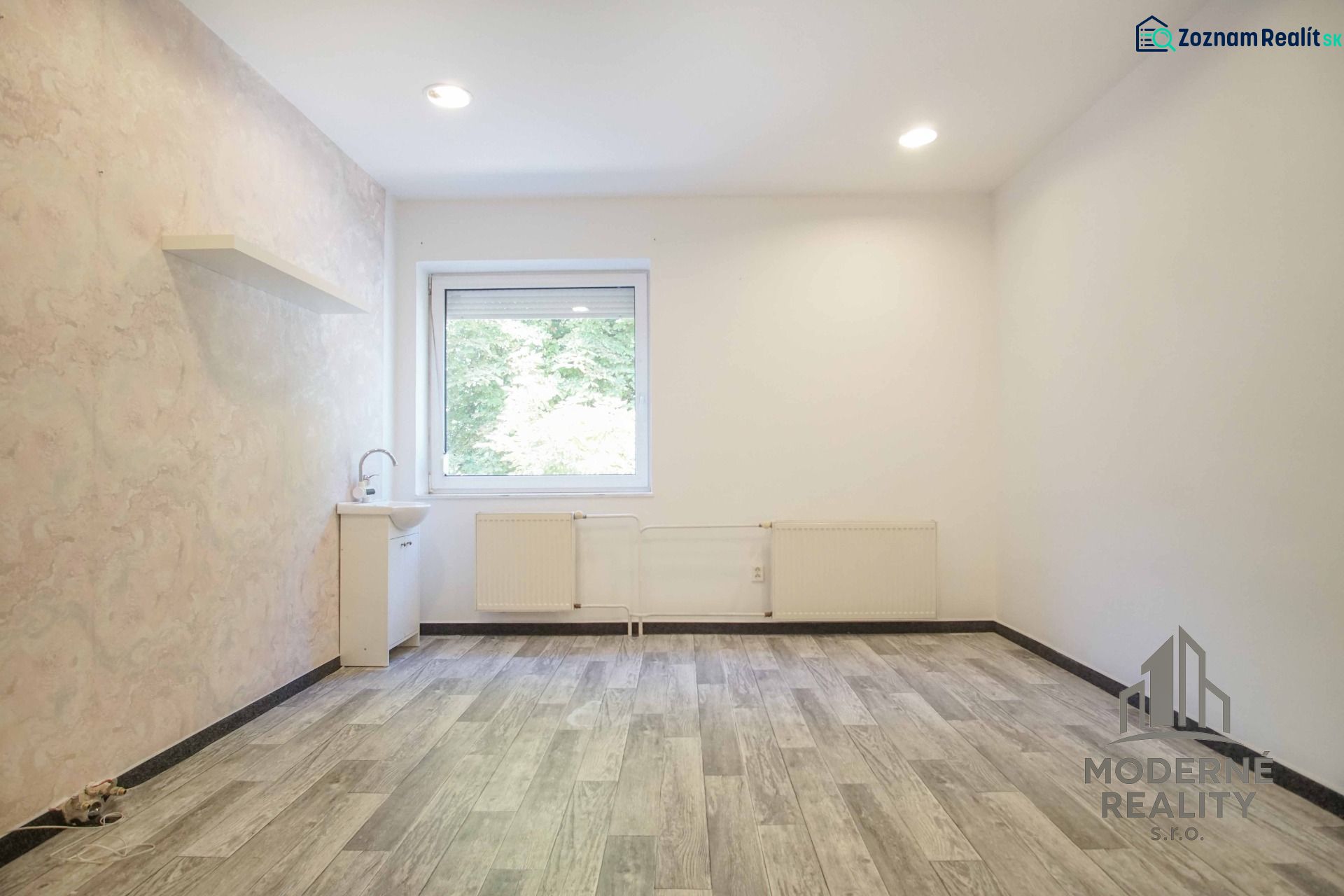 Offices with a pastel wall, a sink, and a wood-patterned floor.