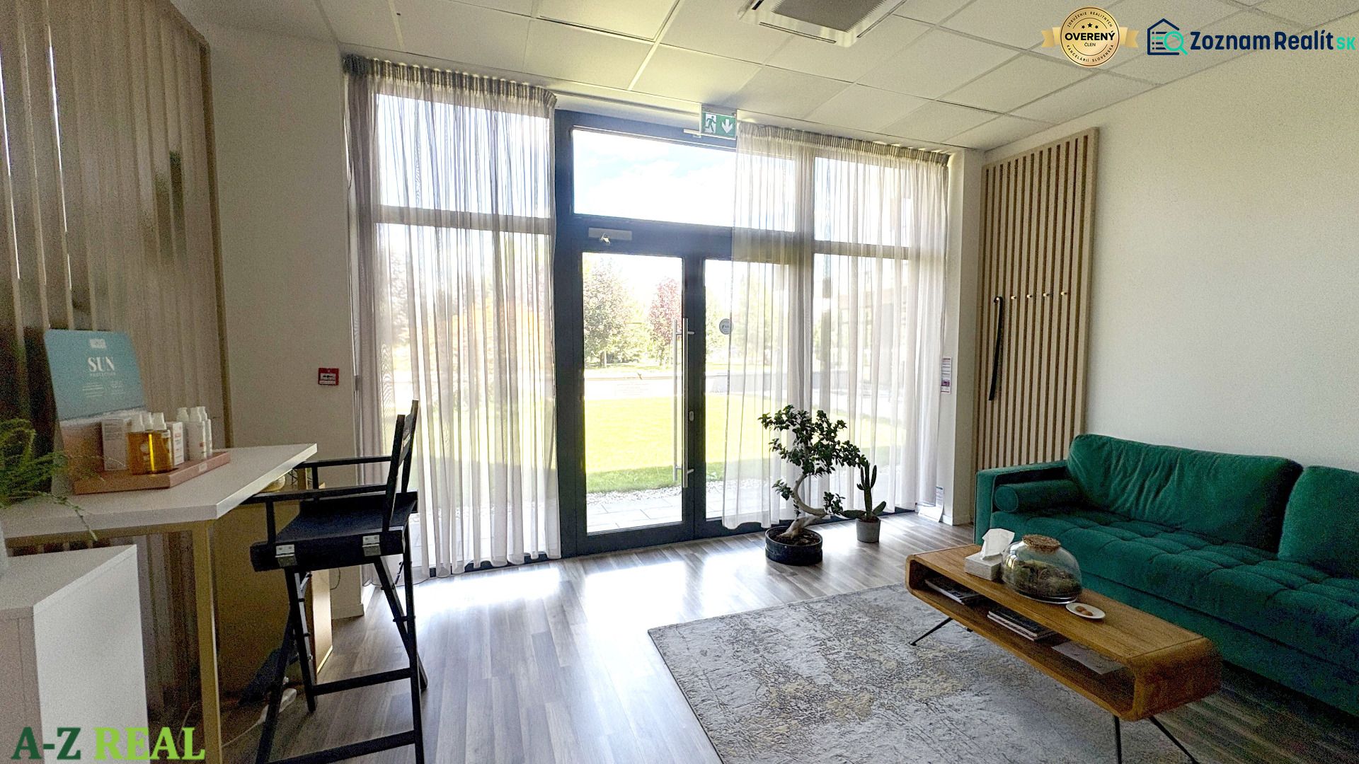 Commercial space with a green sofa, table, and wooden decor flooring.