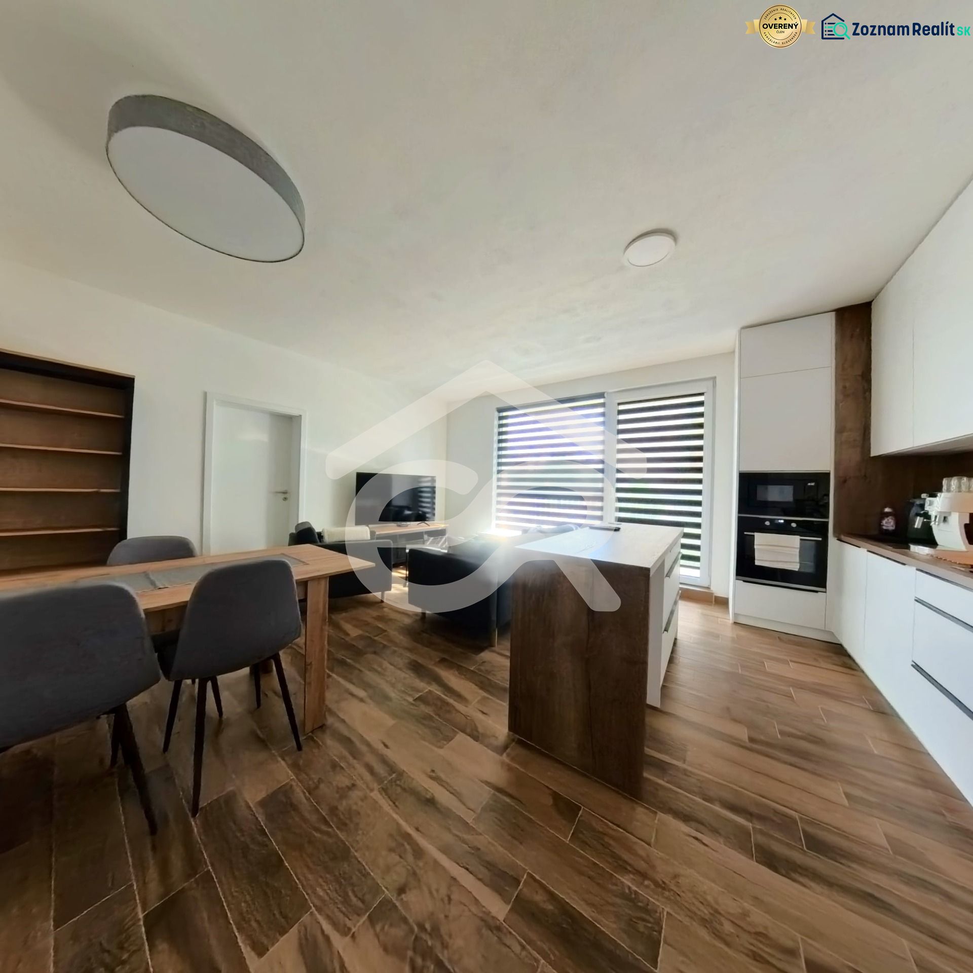 A kitchen in a 3-room apartment with a wooden decor floor and a dining table.