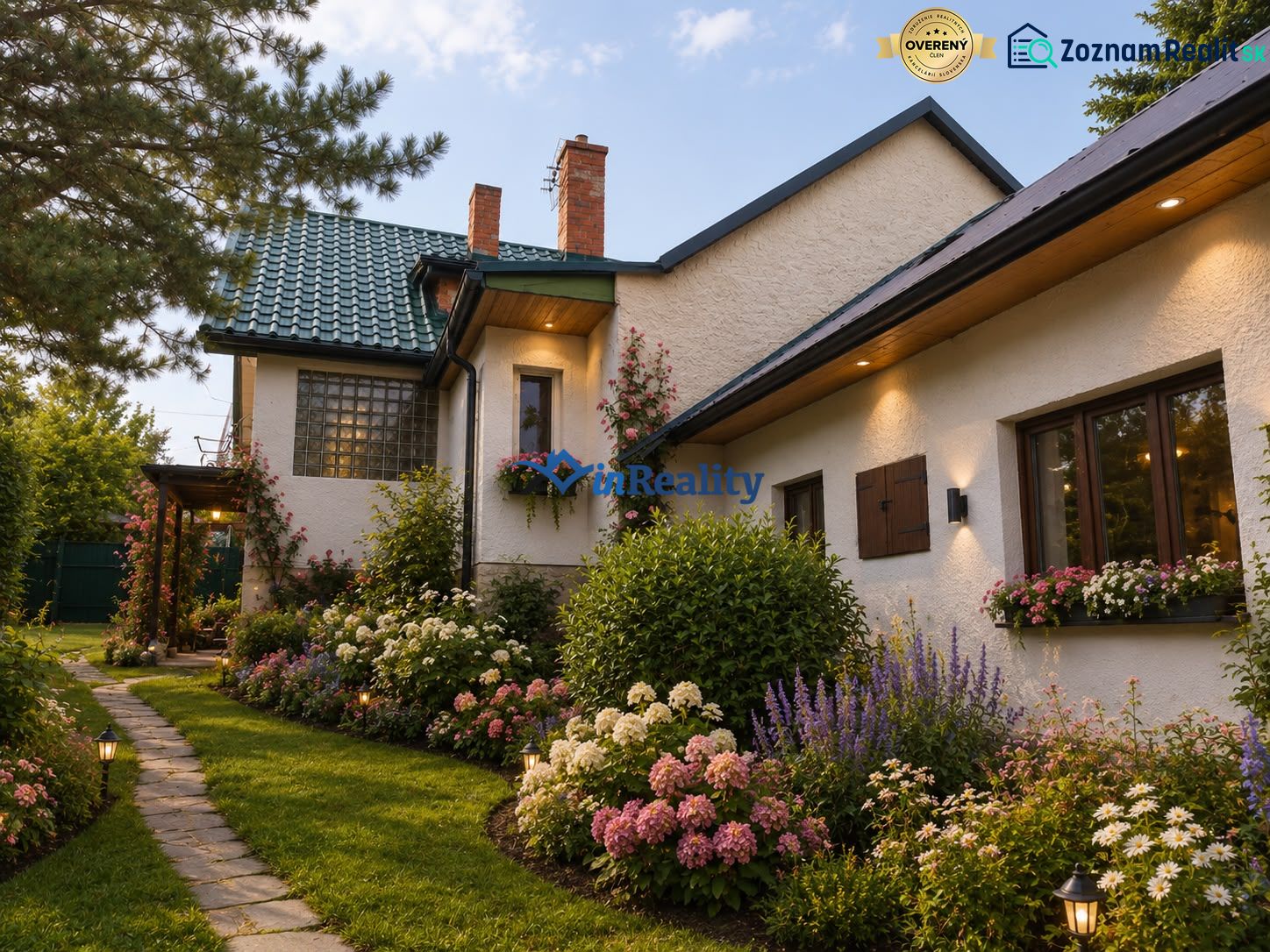 In Kosorín, a family house surrounded by a flower garden and a lit pathway.