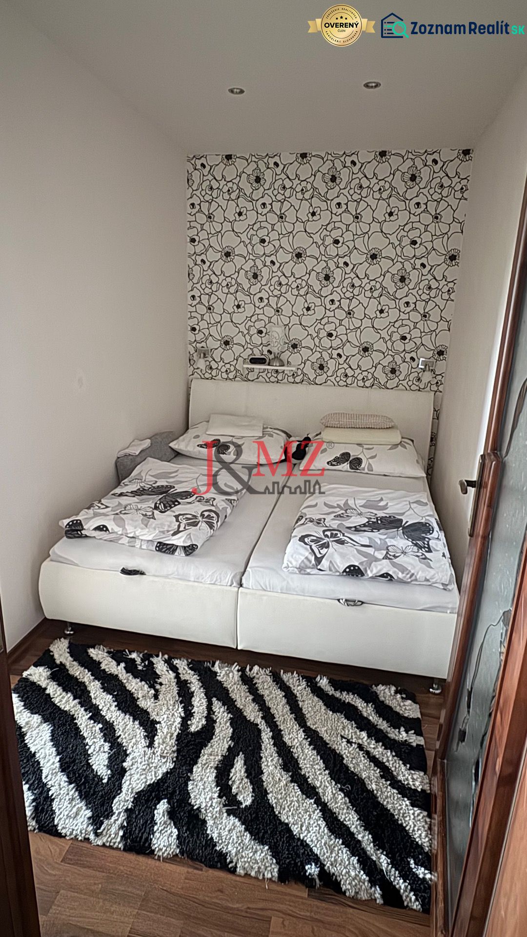 A bedroom in a 3-room apartment with a decorative wall and a floor with a wood decor.