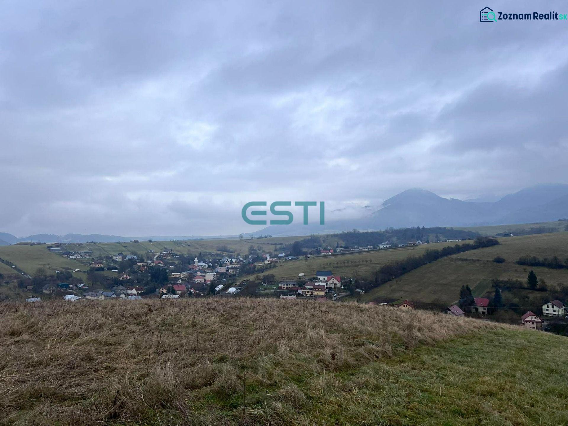 Panorama of agricultural and forest lands in Stránske with a view of the village and mountains.