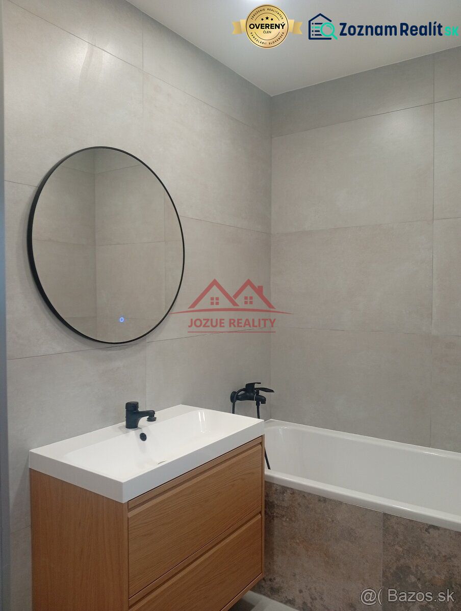 A bathroom with a round mirror and a wooden cabinet in a family house.
