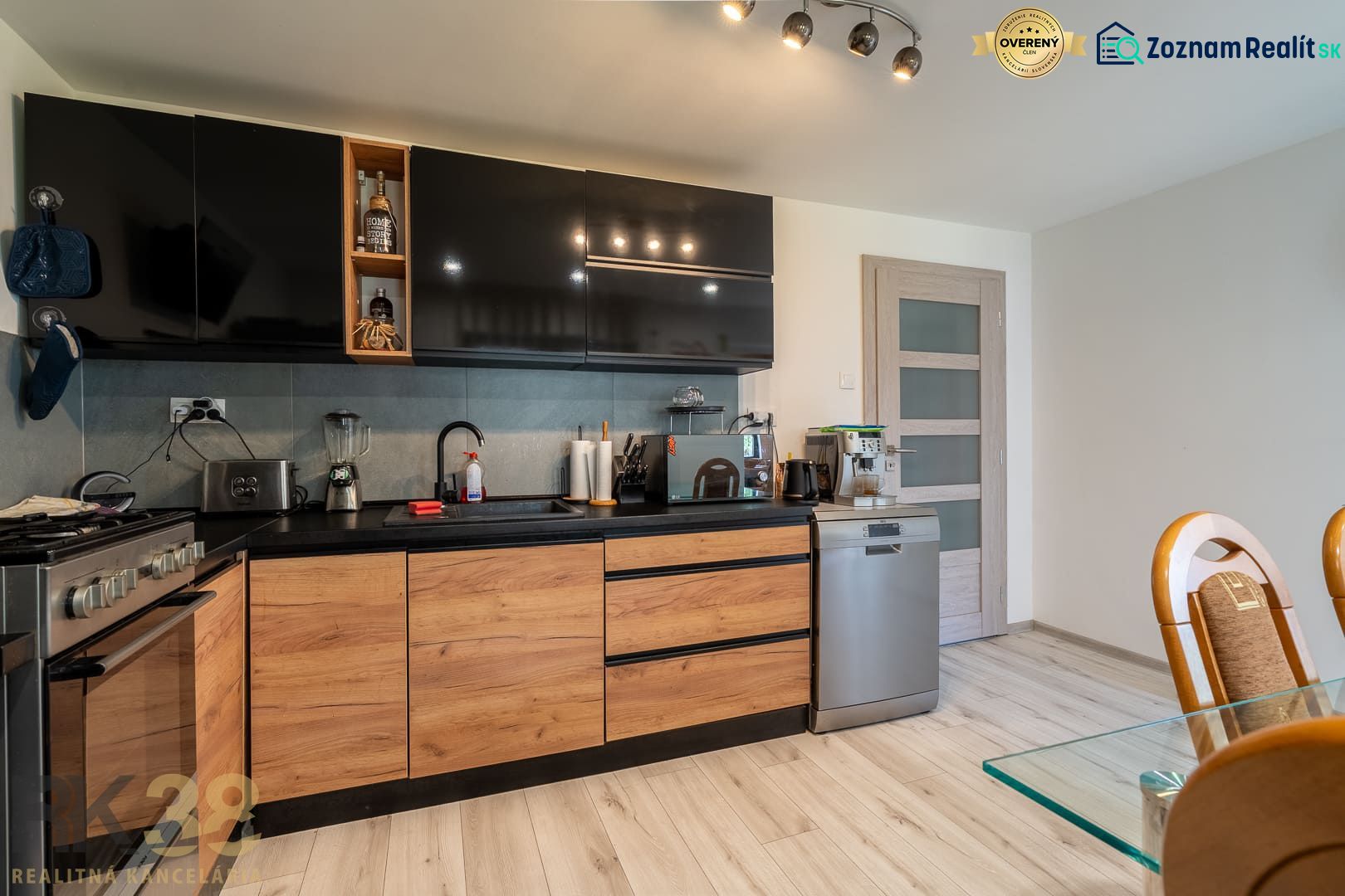 A kitchen in a family house with black cabinets, wooden decor, and appliances.
