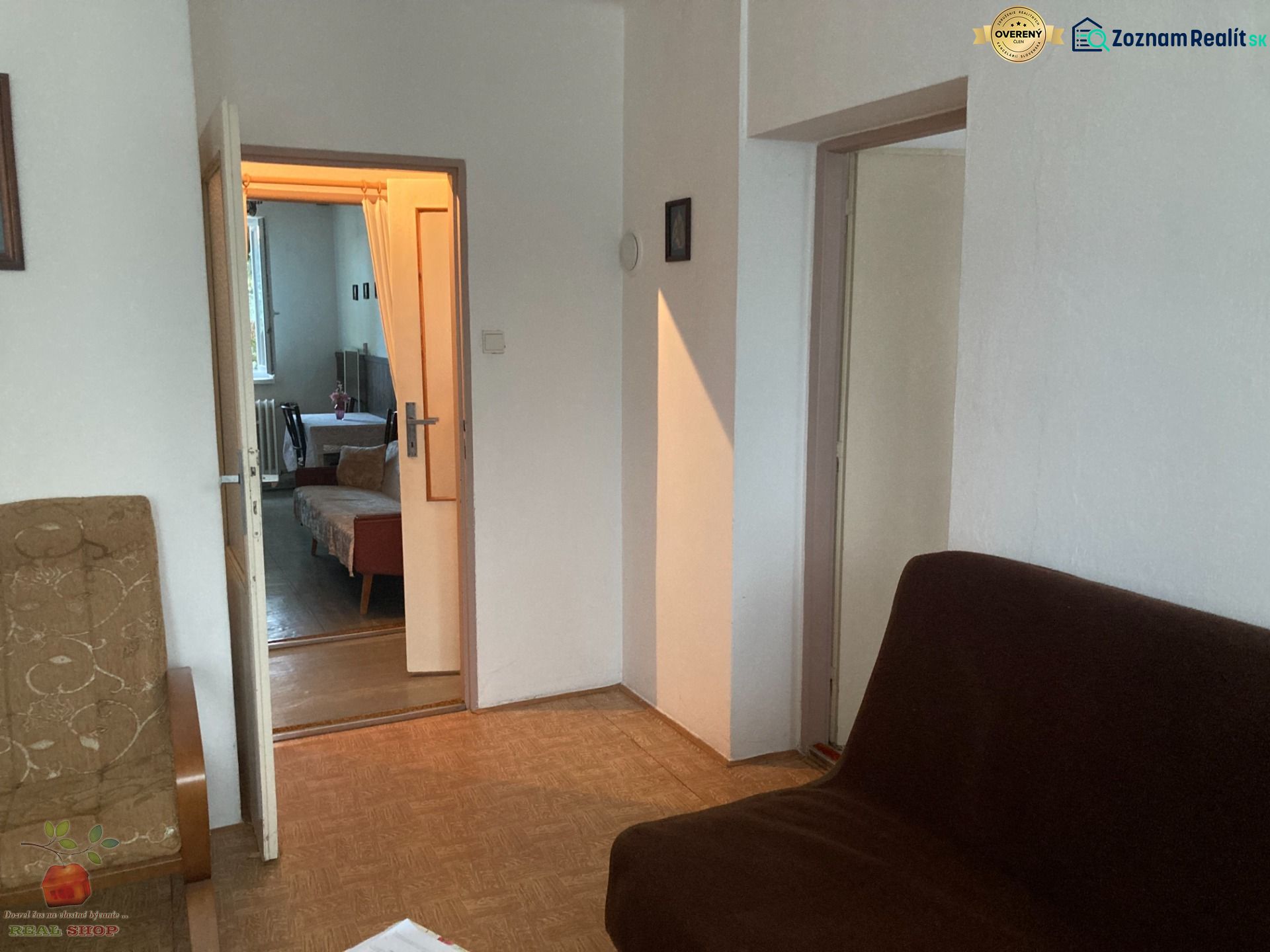A room in a 3-room apartment with a view of the sofas and a wooden decor floor.